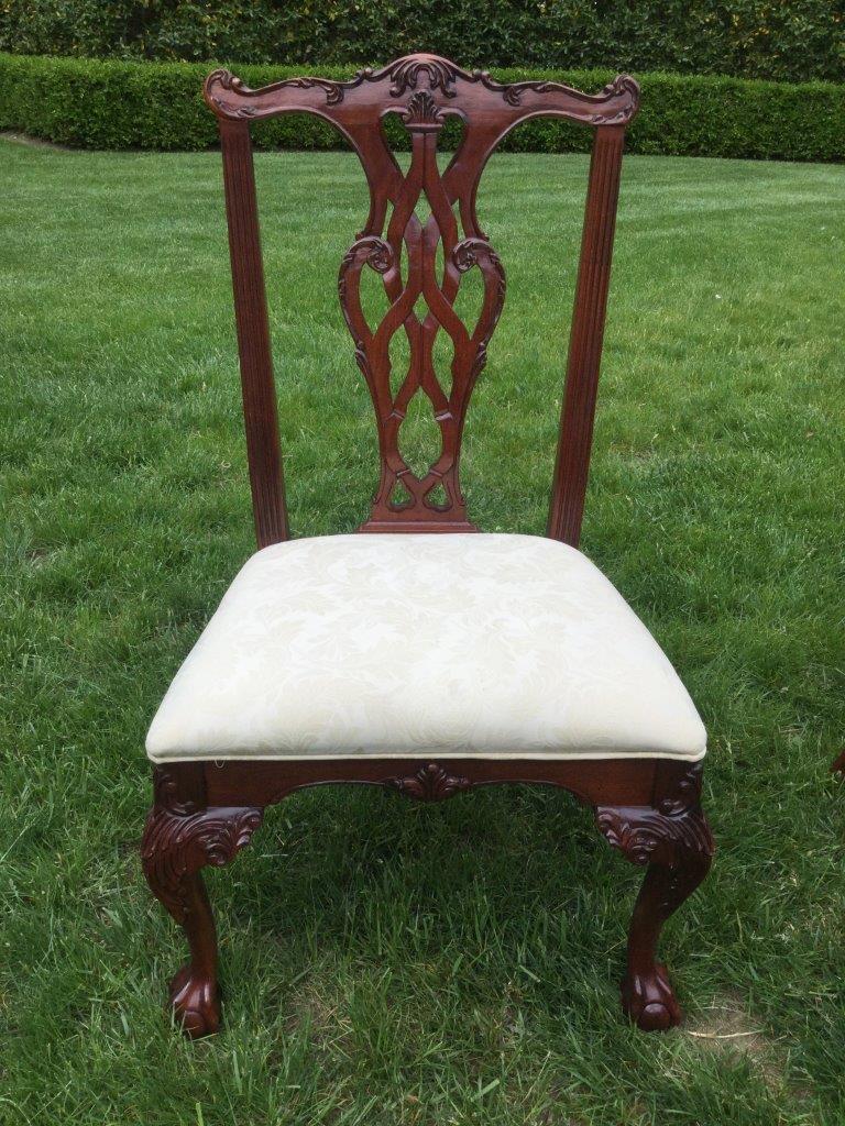 Set of 6 mahogany classic English Chippendale style chairs by Stanley Furniture having carved frames and neutral brocade upholstery. The crest of each chair is finely carved and the claw and ball feet are enhanced with scrolls and acanthus leaves.