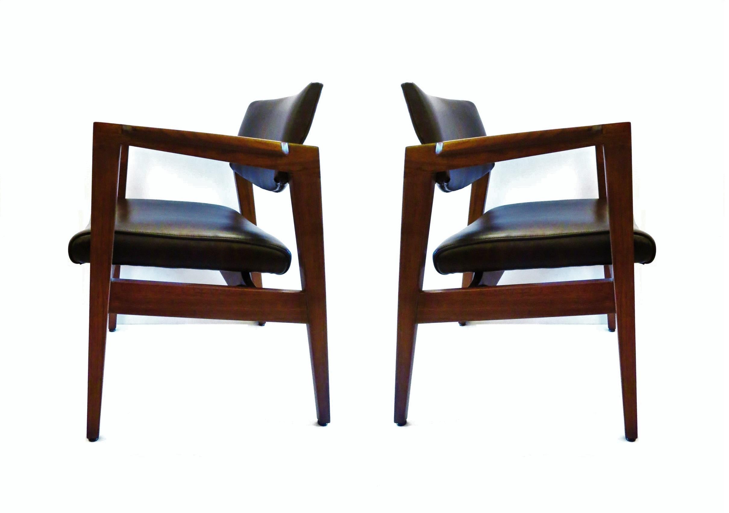 Set of four armchairs by Gunlocke Chair Co of Wayland, NY. With fantastic sculpted walnut wood frames, quality construction you come to expect with Gunlocke furniture. Chairs retain their original upholstery. They have it all, style strength and