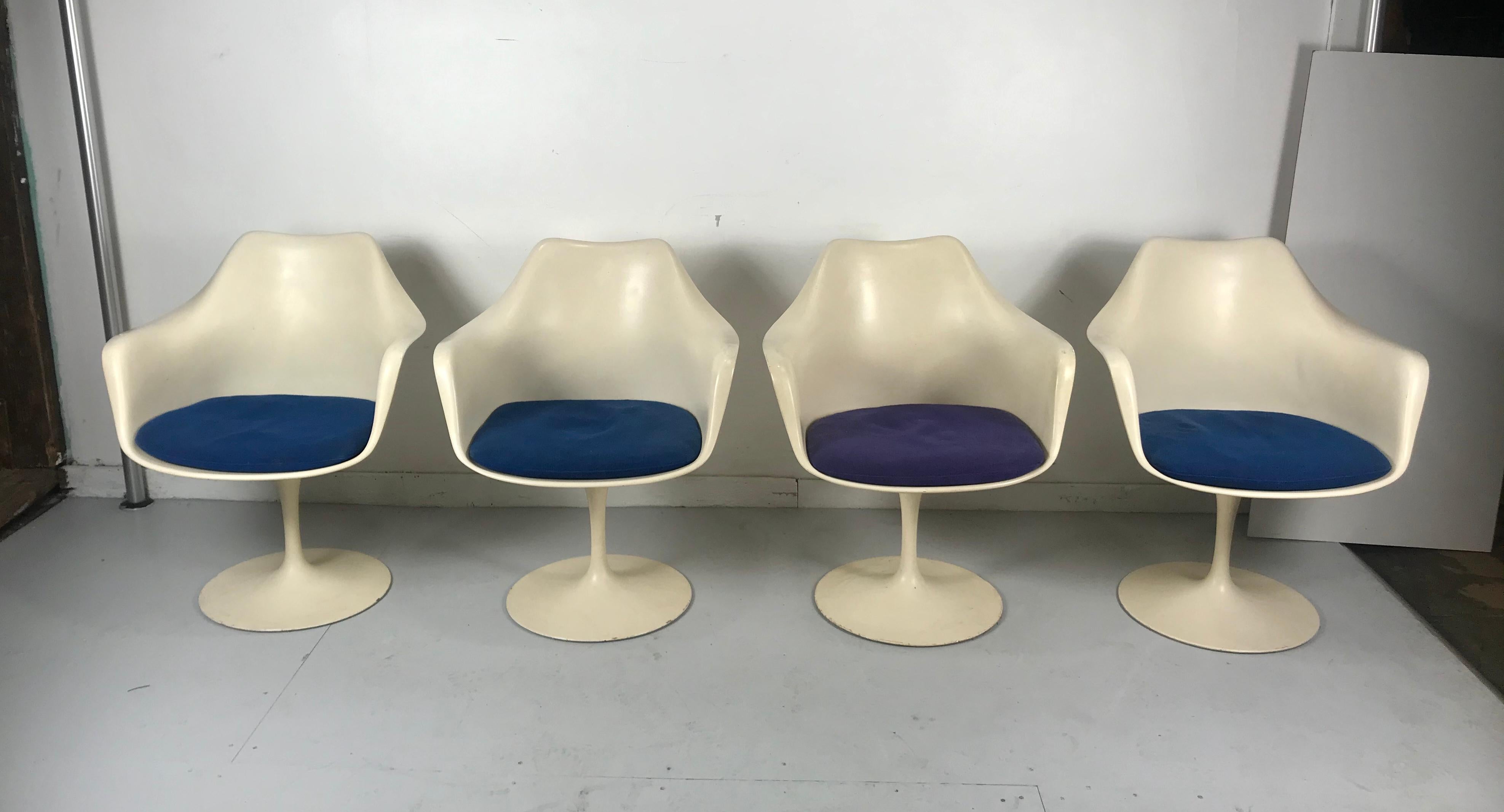 Classic set of four vintage Eero Saarinen Tulip chair. Early Knoll labels. All swivel 360%. Nice vintage set. Retain original seat pads, three blue, one purple. In useable condition, free of rips, tears, dry-rot etc. minor soiling. Original