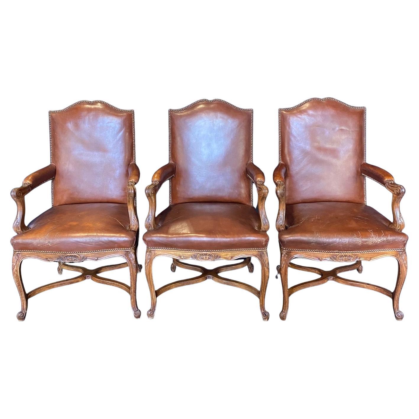Set aus drei französischen Bergere-Sesseln aus geschnitztem Holz und Leder im Angebot