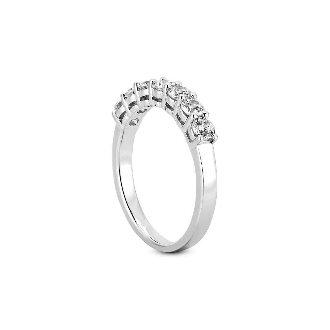 Classic prong set diamond band in 14k white gold. Band contains a single row of seven natural, round white brilliant cut diamonds, weighing a combined carat weight of 0.85 ctw, G-H color, SI clarity.

 