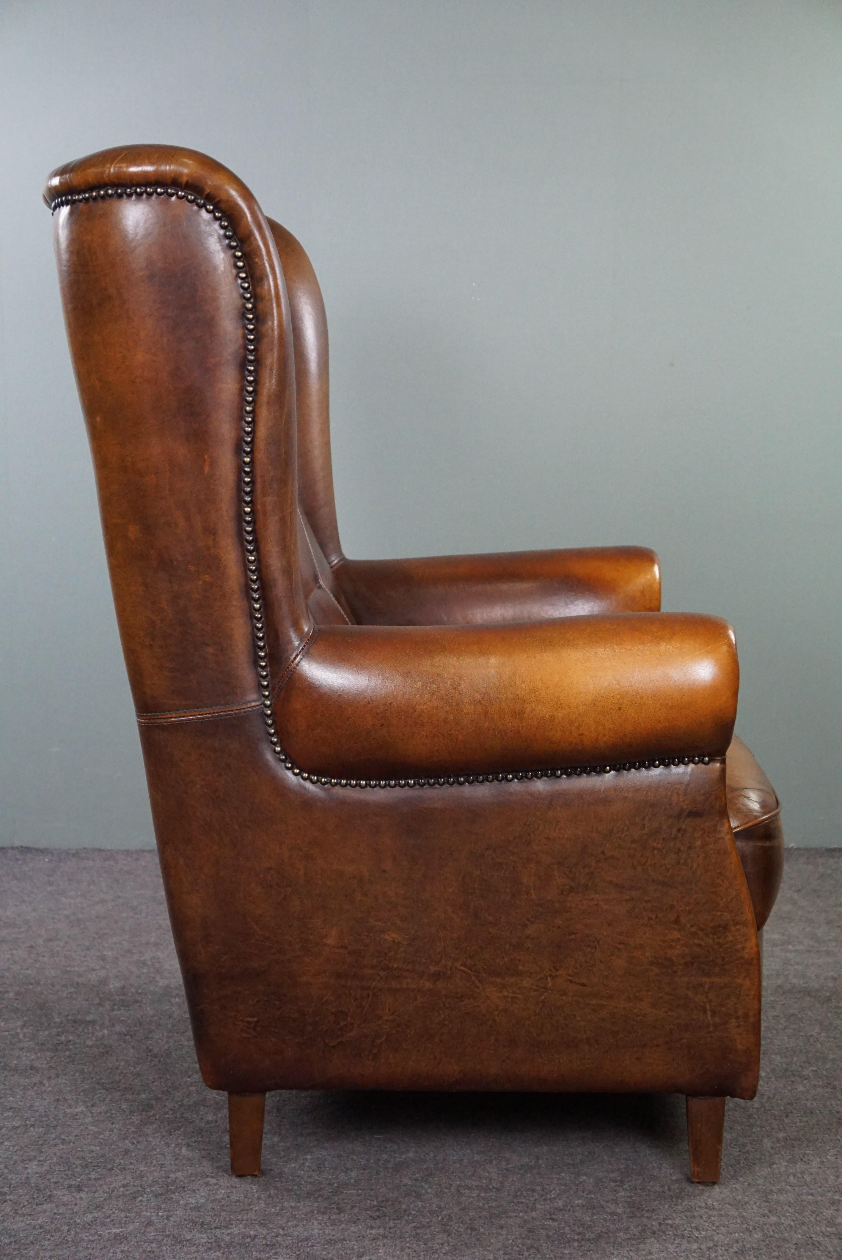 Classic sheepskin wingback chair with a beautiful patina In Good Condition For Sale In Harderwijk, NL