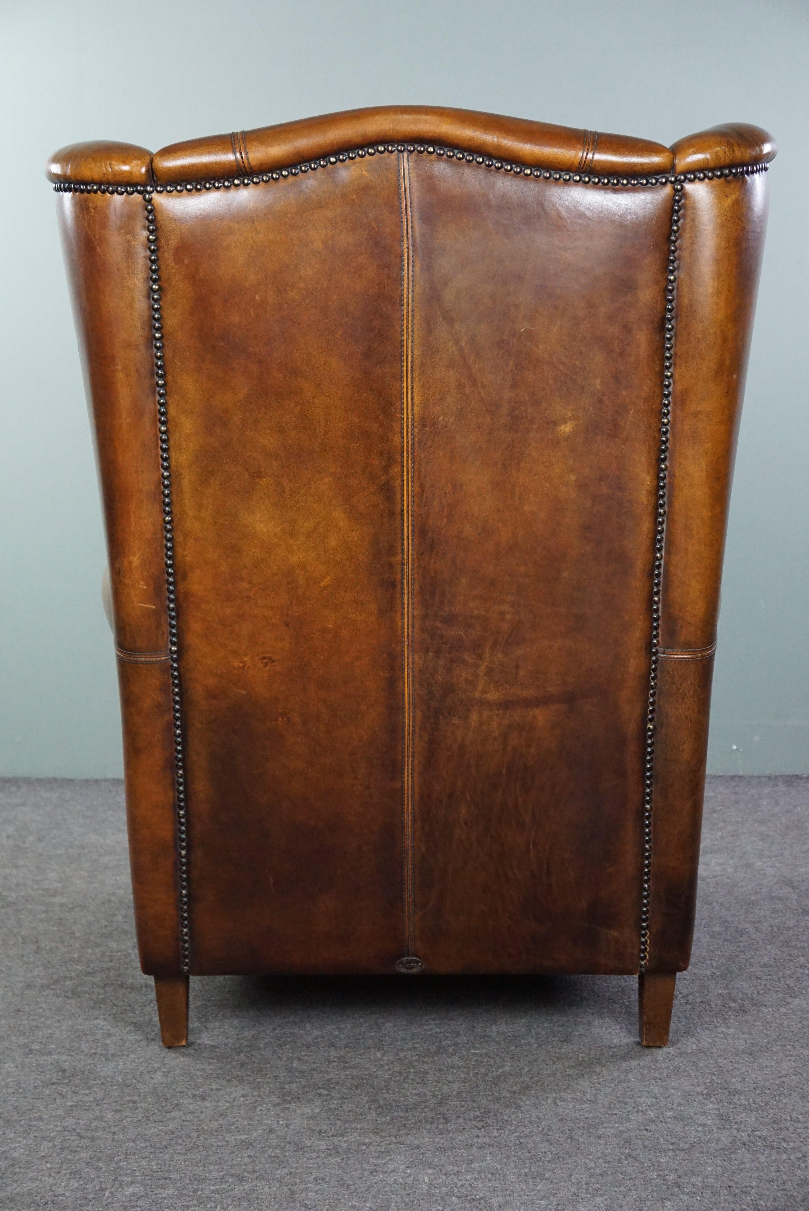 Late 20th Century Classic sheepskin wingback chair with a beautiful patina For Sale