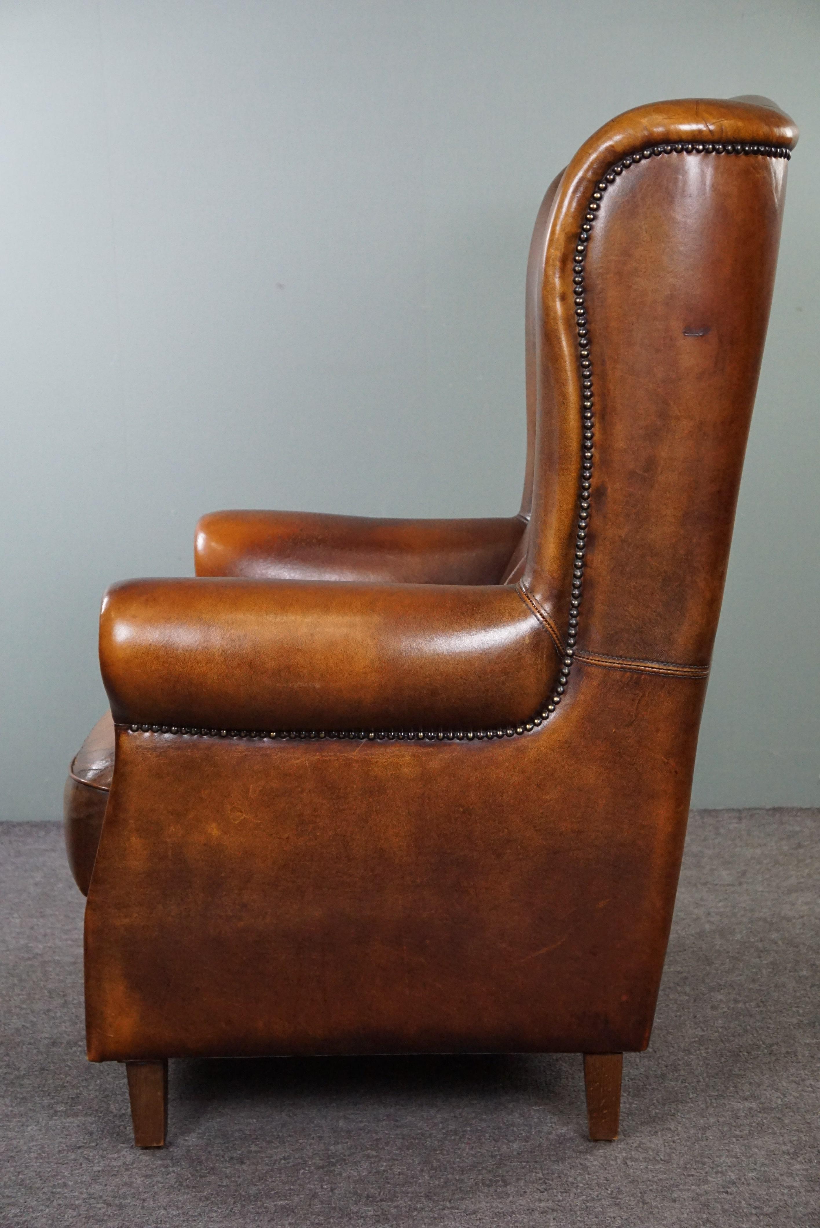 Leather Classic sheepskin wingback chair with a beautiful patina For Sale
