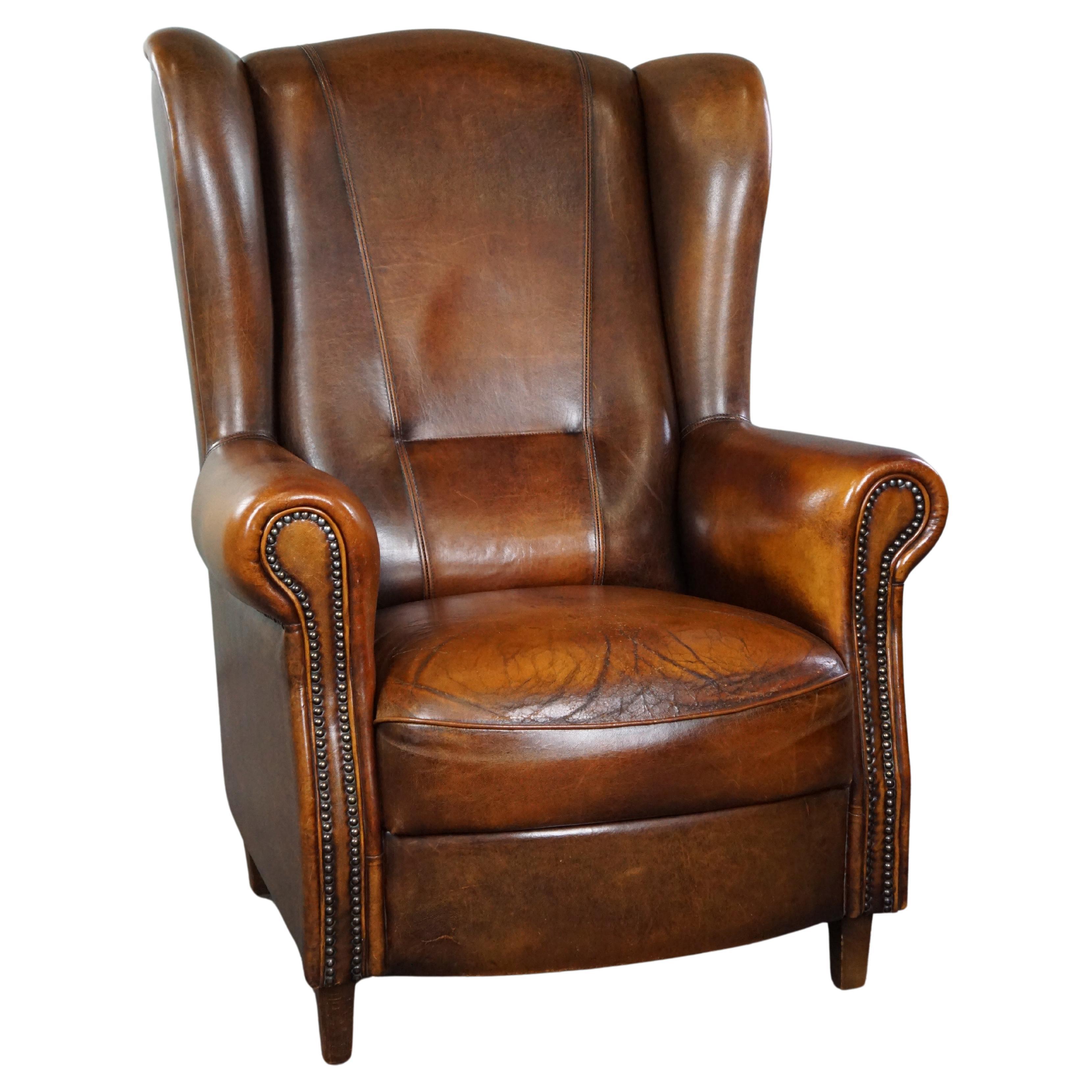 Classic sheepskin wingback chair with a beautiful patina For Sale