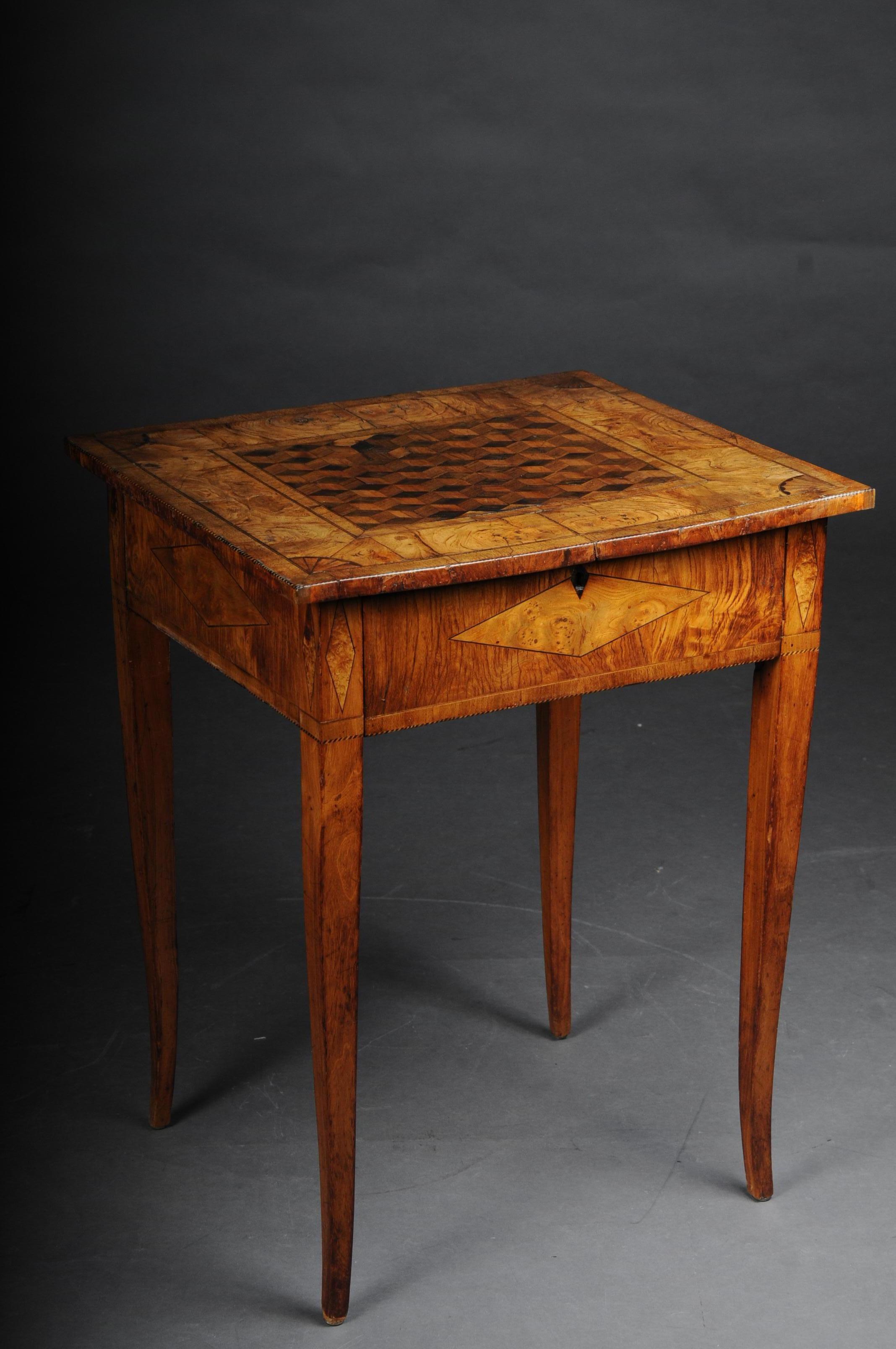 Classic side table classicism, circa 1810 ash, inlaid.

Solid wood veneered with ash. Sliding straight frame socket on pointed legs. Overhanging cover plate. Rich marquetry or cube inlaid. Cover plate edge framed with thread inlays.

(G-79).