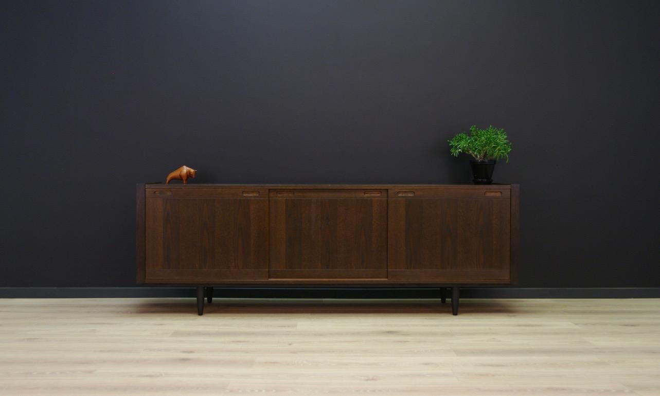 Original sideboard from the 1960s-1970s, Minimalist Danish design. Manufactured in the Skovby Møbelfabrik manufacture. Furniture covered with oak veneer. Spacious interior behind sliding doors with shelves and drawers. Adjustable shelves. Preserved