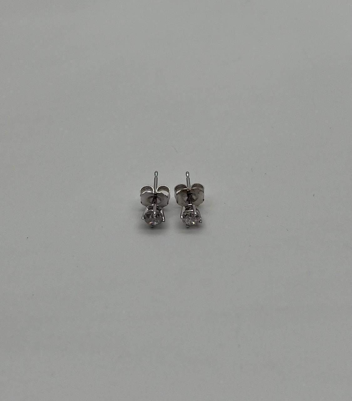 Elegant diamond stud earrings
Each earring features a single, brilliant-cut diamond set in a classic four-prong setting.
The diamonds are mounted on sleek, polished metal posts, ensuring a secure fit.
14K White Gold