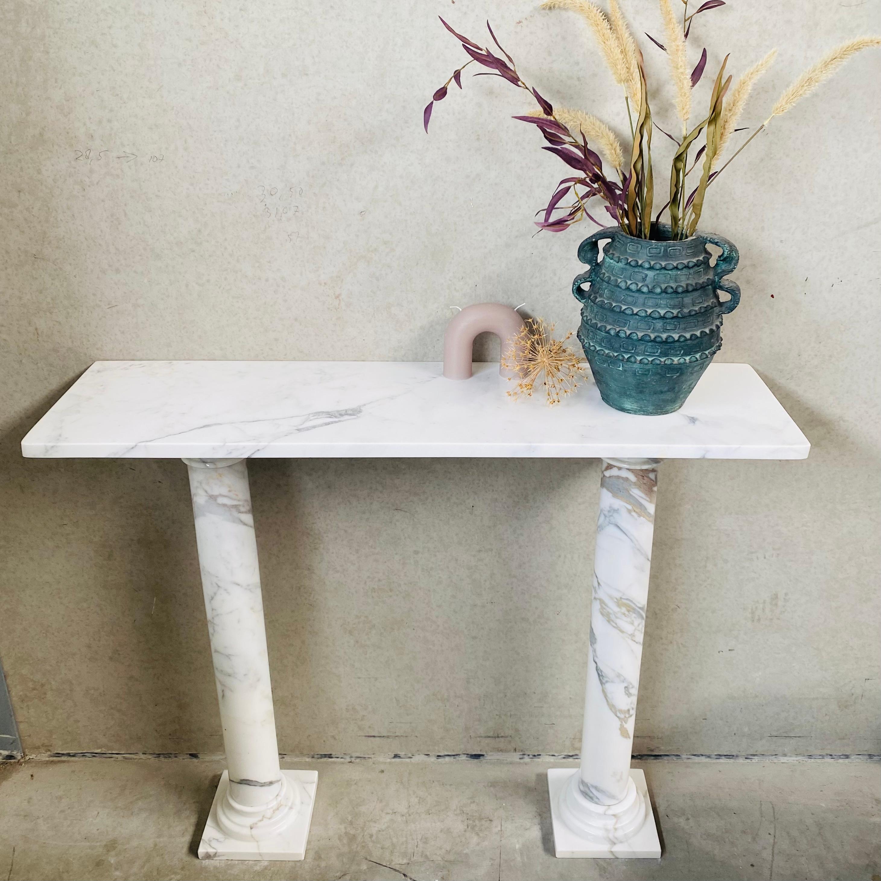 
Welcome to our exquisite collection of vintage solid white marble console tables with two pedestals and beautiful marble lining! This stunning piece, hailing from Italy in 1980, is the perfect addition to elevate the interior of your space with its