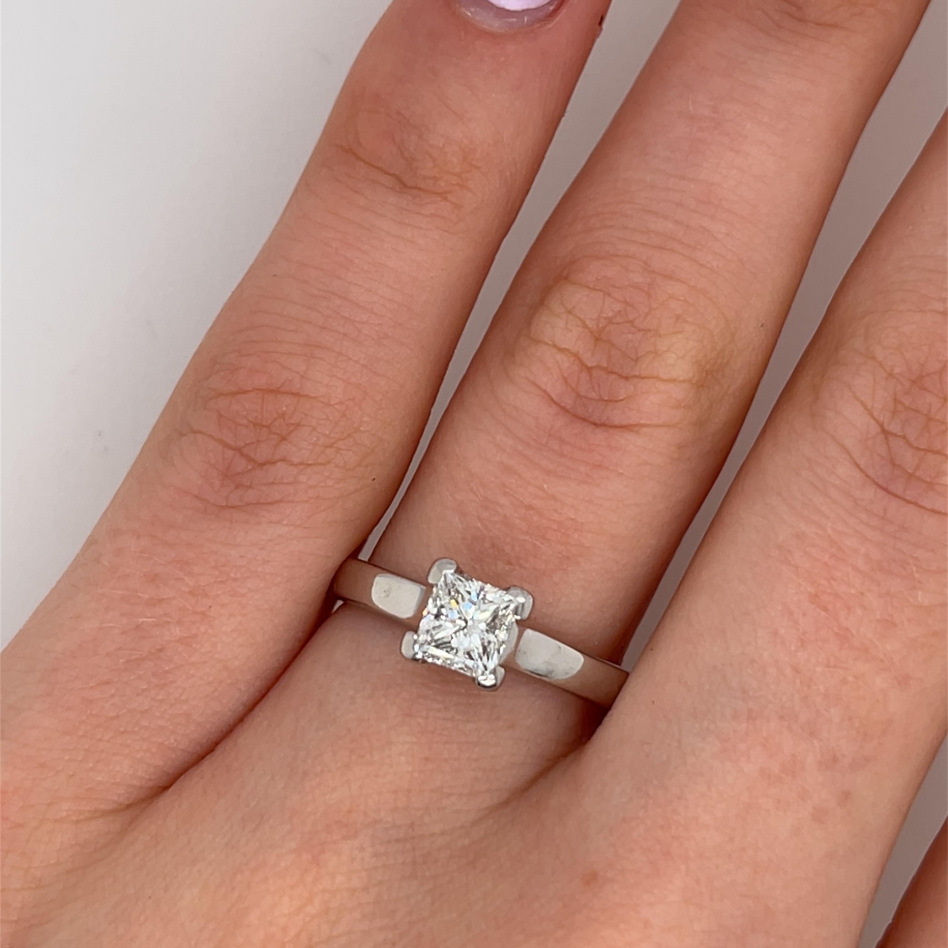Un anillo de compromiso solitario atemporal, 
con un diamante talla princesa de 0,81 qt certificado por el GIA, de color E y claridad VVS1 para un brillo y una pureza excepcionales. El diamante está elegantemente engastado en un refinado oro blanco