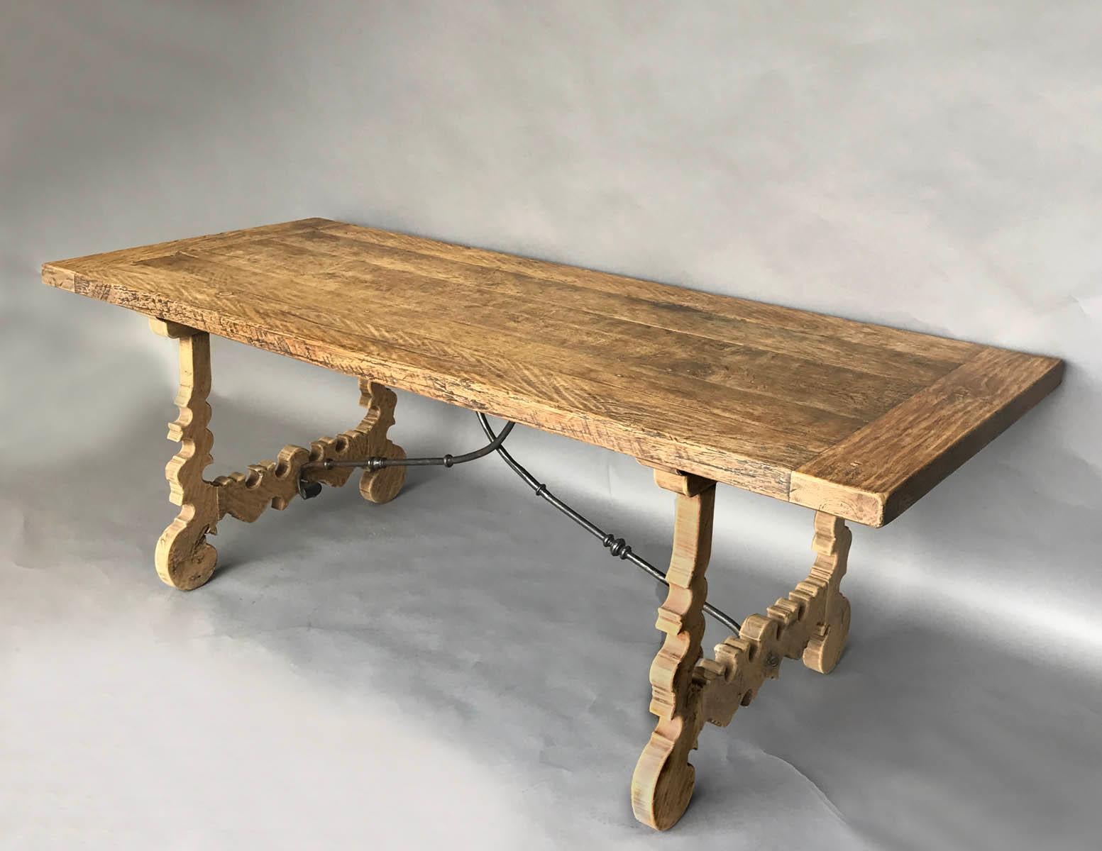 19th century Spanish trestle table with a naturally distressed finish commensurate with age and use. A Classic lyre leg table with iron stretchers. Natural smooth natural wood patina, chestnut. Could be a marriage of two different tables. Would make