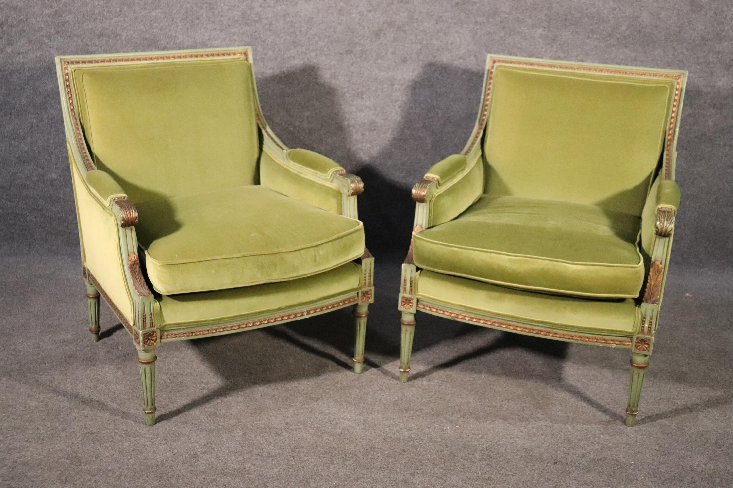 This is a gorgeous pair of classic 1950s era French Louis XVI style bergere chairs. The chairs are upholstered in a green velvet and are in good condition. The cushions have foam cores which may need to be replaced due to age. The frames are in good