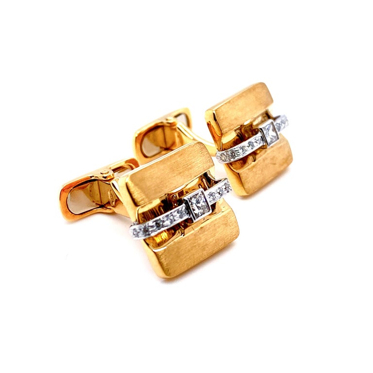 This set of classic 18 karat white and yellow gold square cufflinks are crafted with a brilliant square cut diamond alongside 10 round diamonds on each side. Simple yet substantial. This piece in excellent condition was entirely made in Dilys’