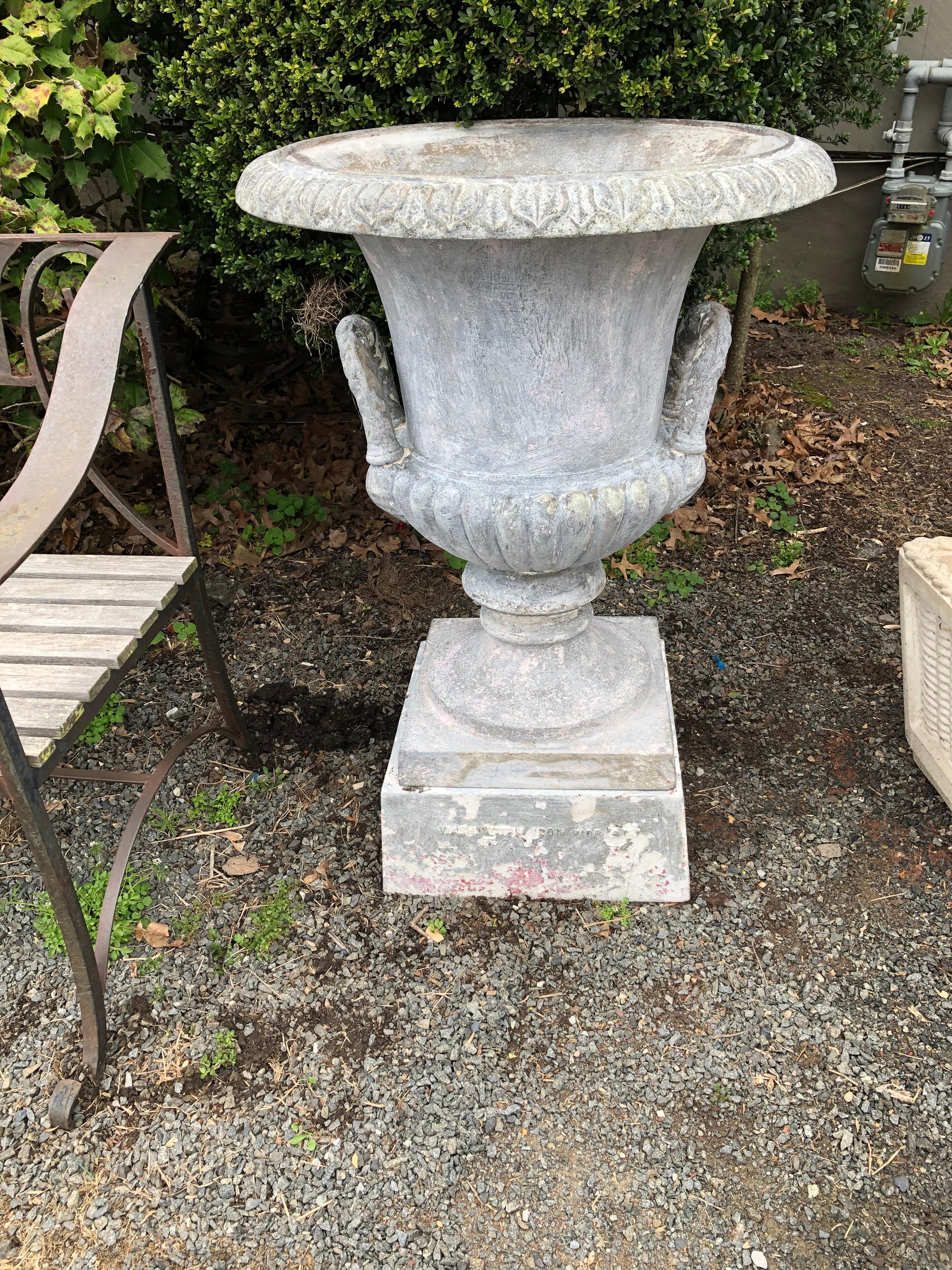 Gorgeous neoclassical style 19th century iron urn stamped Mott Iron Works with classic detailing and grey patina. Married to a plinth by a different maker.
Measures: Base is 15