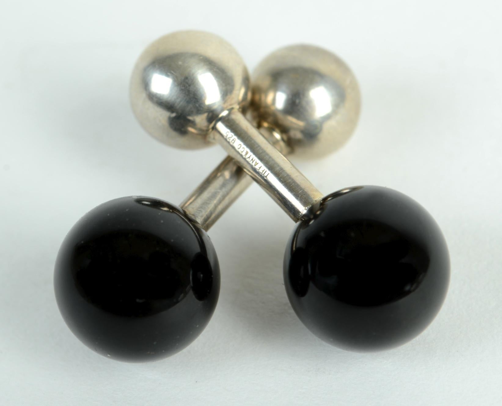 Classic Sterling Silver and Black Onyx Barbell Cufflinks by Tiffany & Co. They are reversible, sterling ball or black onyx, or one of each. Both are signed Tiffany & Co. 925. 
N.P. Trent has been a respected name in antiques for over 30 years with a