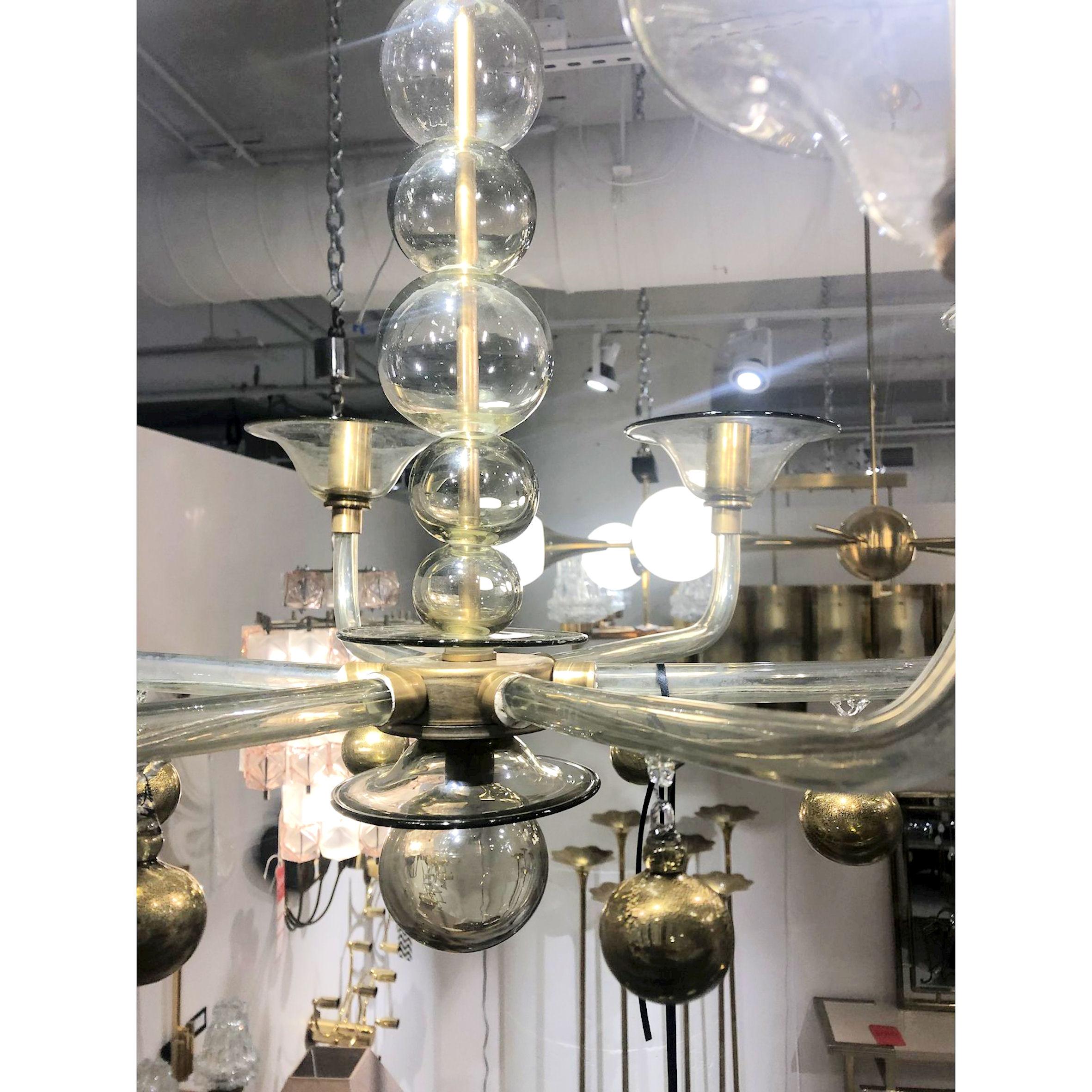Mid-Century Modern chandelier by Venini, Italy, 1970s. 
Chandelier features six glass arms with hand blown detailing, including round orbs.
The Murano glass has a beautiful transparency, with a light gray color, showing the inside brass mounts,