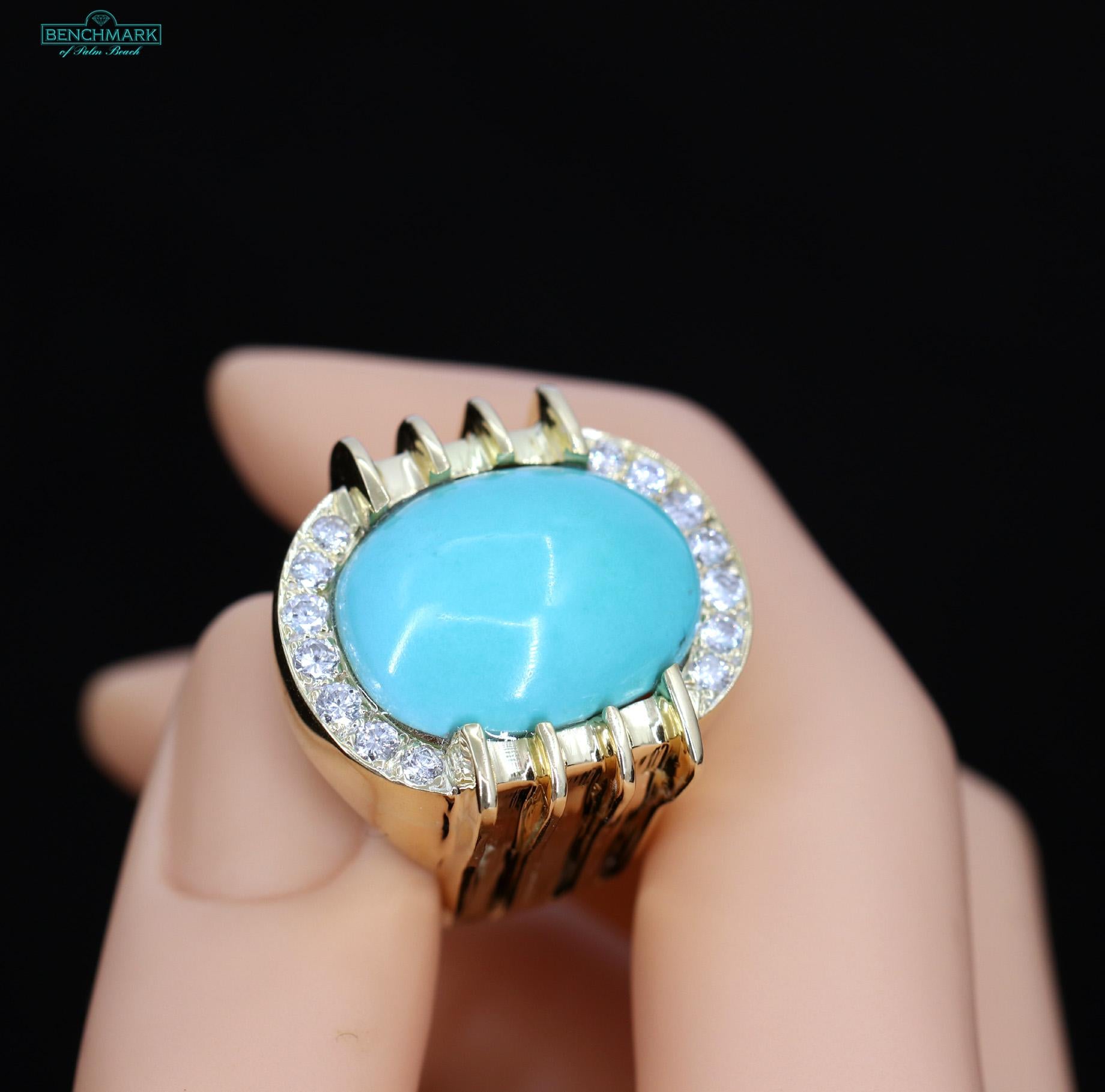 An 18K yellow gold ring centered around a cabochon turquoise measuring 22mm by 17mm, and featuring 7 round brilliant cut diamonds on the north side and 7 round brilliant cut diamonds on the south side of the ring for a total approximate weight of