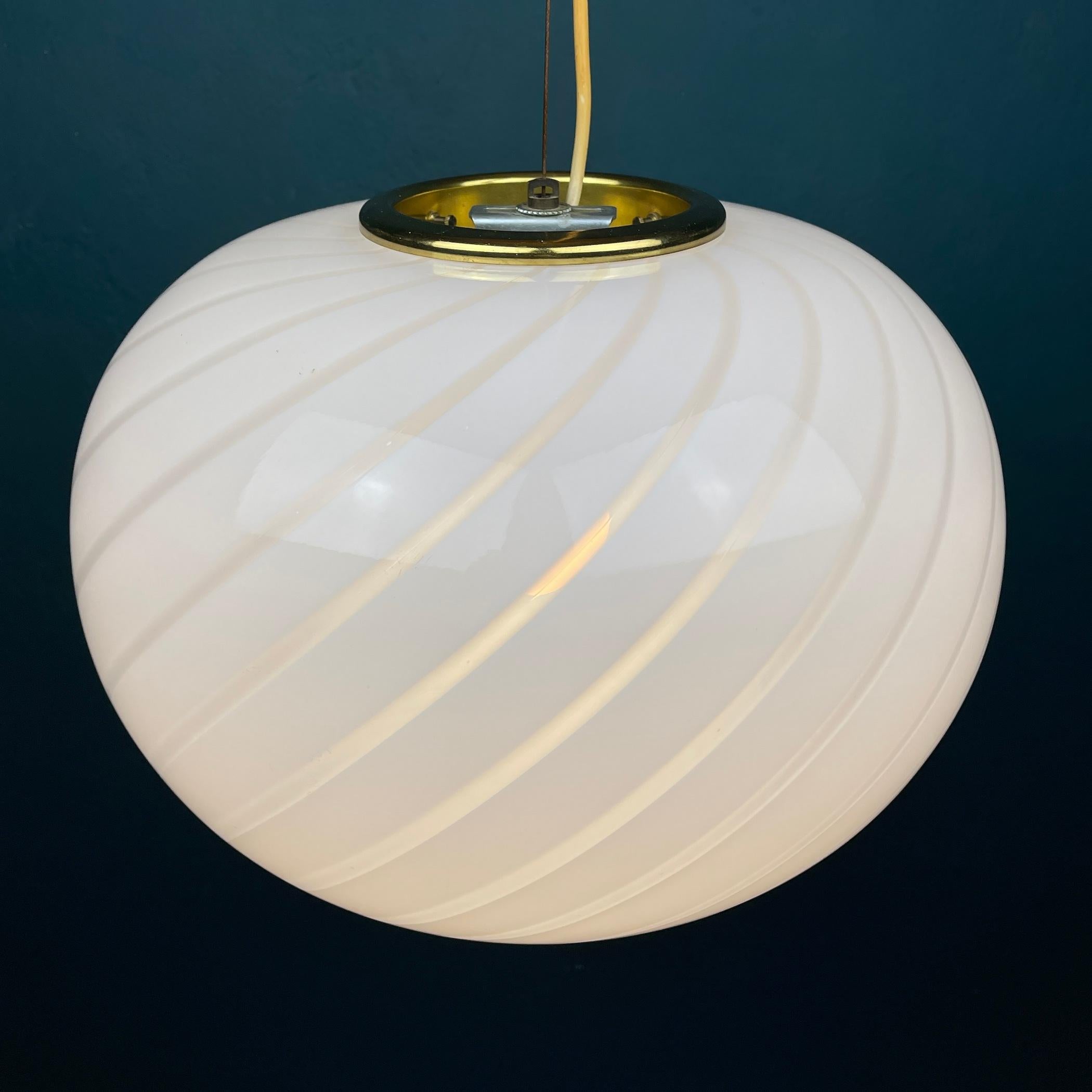 This swirl vintage lamp was made in Italy in the 70s. Very beautiful white Murano glass with bends in the form of a sphere. Perfect vintage condition. No chips or cracks. Requires a standard Edison E27 with a screw lamp. Chandelier height with cable