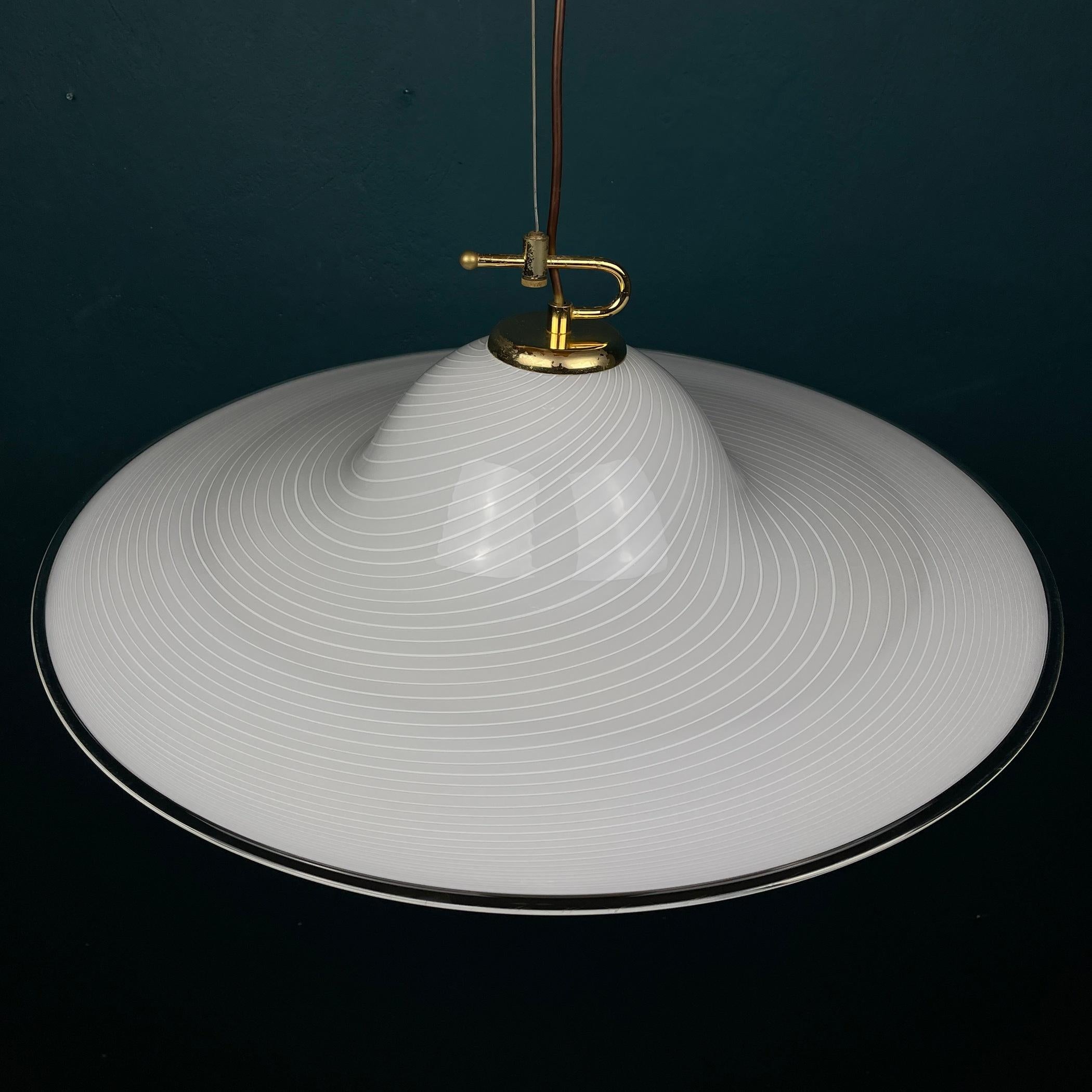 This swirl vintage Murano pendant lamp Vetri Murano was made in Italy in the 1970s. Very beautiful white Murano glass with bends in the form of a tulip. Perfect vintage condition. No chips or cracks. Requires a standard Edison E27 with a screw lamp.