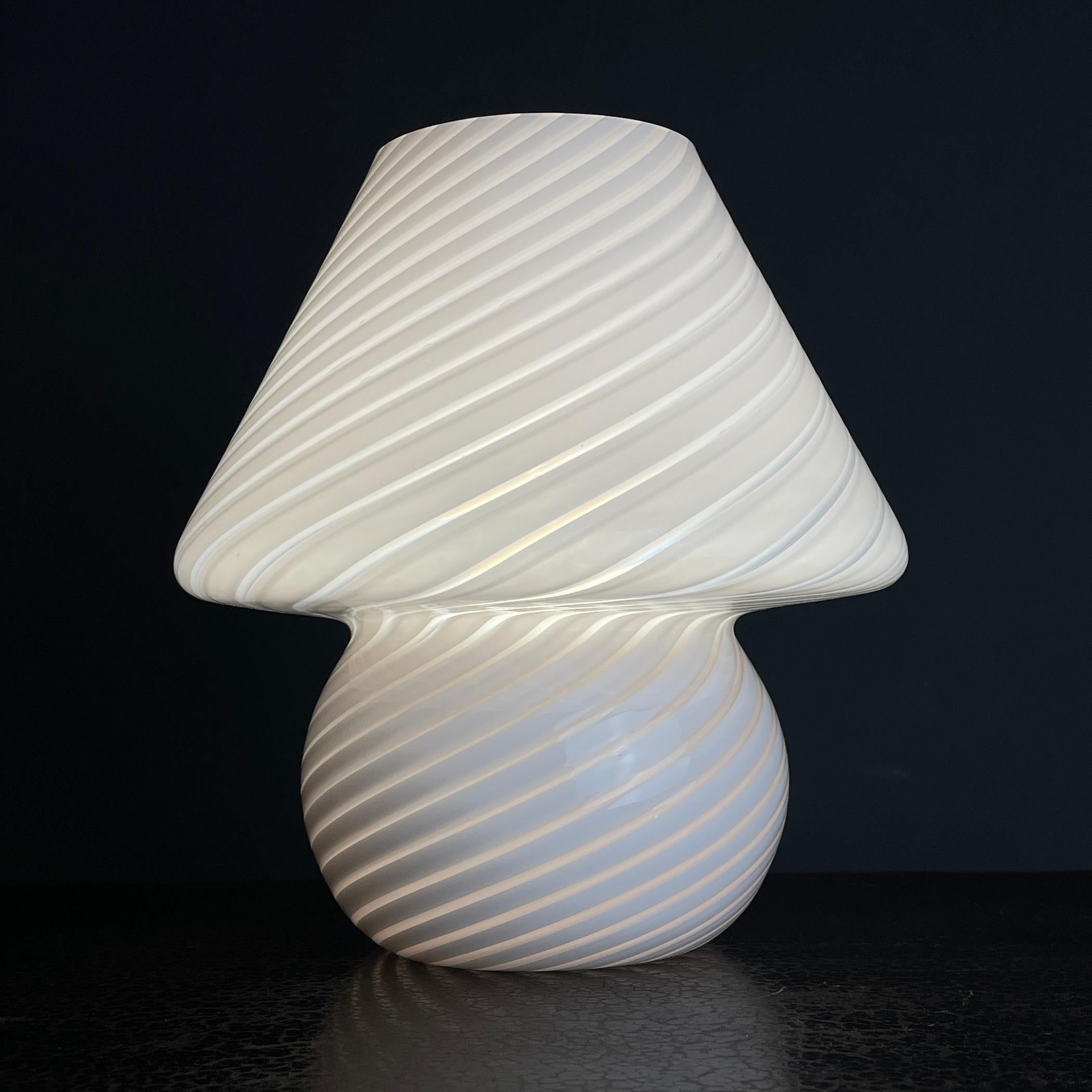Embrace the classic allure of Italian design with this exquisite vintage Murano mushroom lamp. Crafted in the 1970s, this lamp showcases the beauty of a bygone era with its captivating pink swirl design. Step into the past with this lamp's timeless