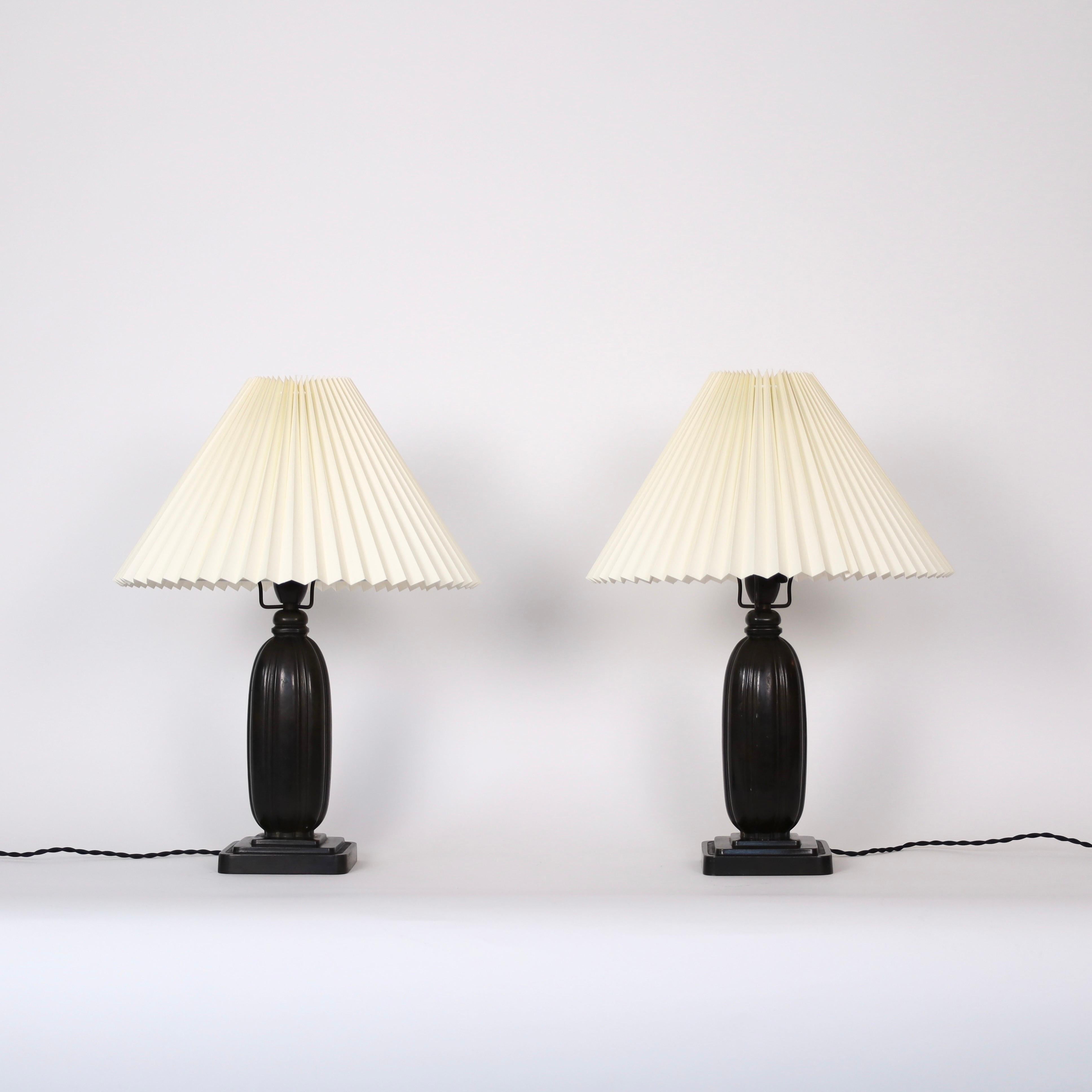 Set of timeless no. 1859 Just Andersen Table Lamps made in 1936. A rare set for an exquisite home. 

* Set of square metal desk lamps with vertical lines and pleated shades.
* Designer: Just Andersen
* Model: 1859
* Year: 1936
* Condition: Good