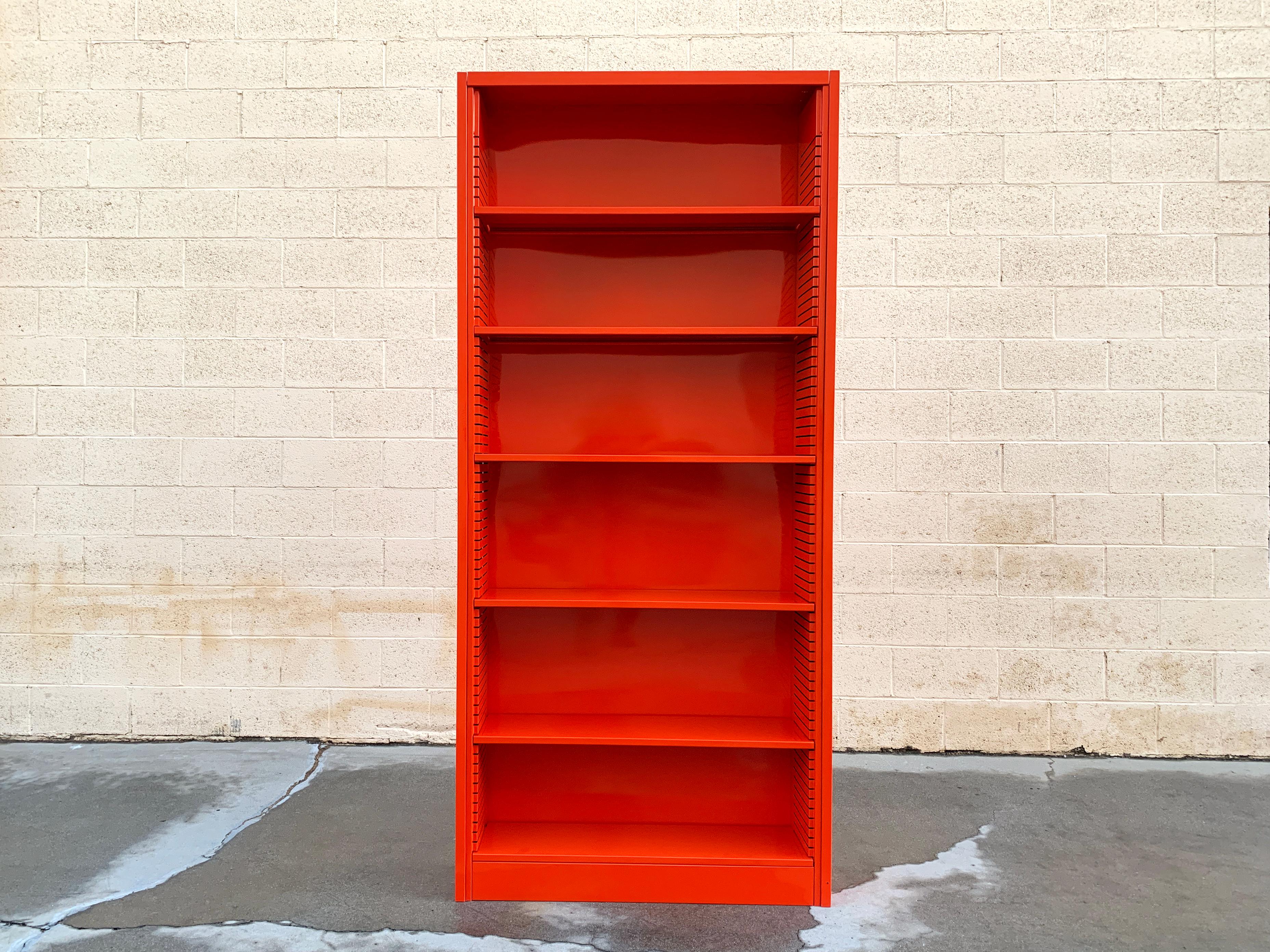 It's the 1970s tall tanker bookcase refinished in high Safety Orange (OG26). This minimal, unit with six adjustable shelves, is perfect for storage and display. In excellent refinished condition with gentle wear to the steel based on age. 

This