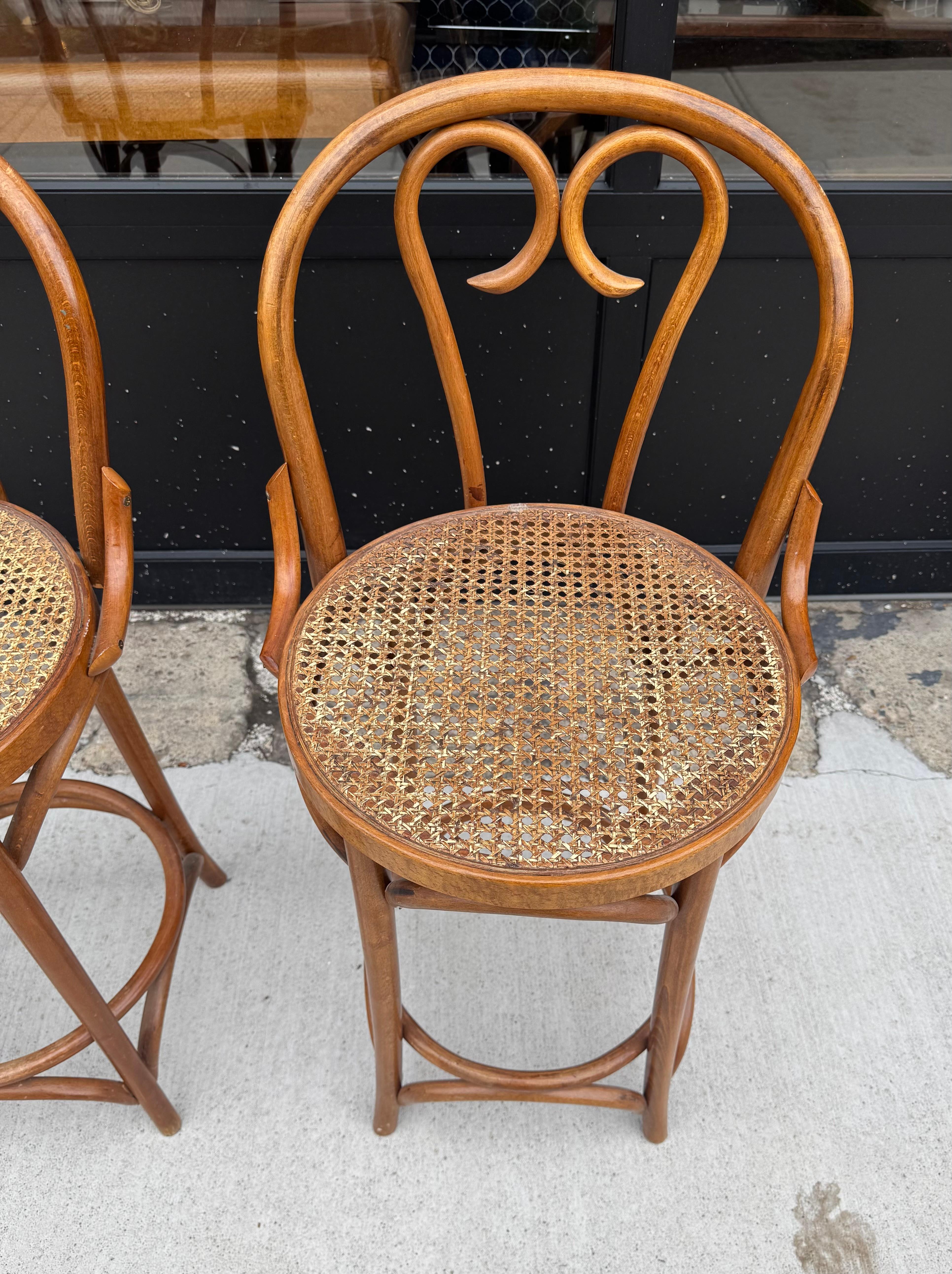 Ein Paar Bugholz-Barhocker mit Rückenlehnen im Thonet-Stil aus der Mitte des 20. Hohe Hocker in Thekenhöhe mit Fußstütze. Beide Hocker versuchen, in sehr gutem Zustand, solide mit keine Probleme. Unterschrieben... hergestellt in Rumänien

37H
24Sitz