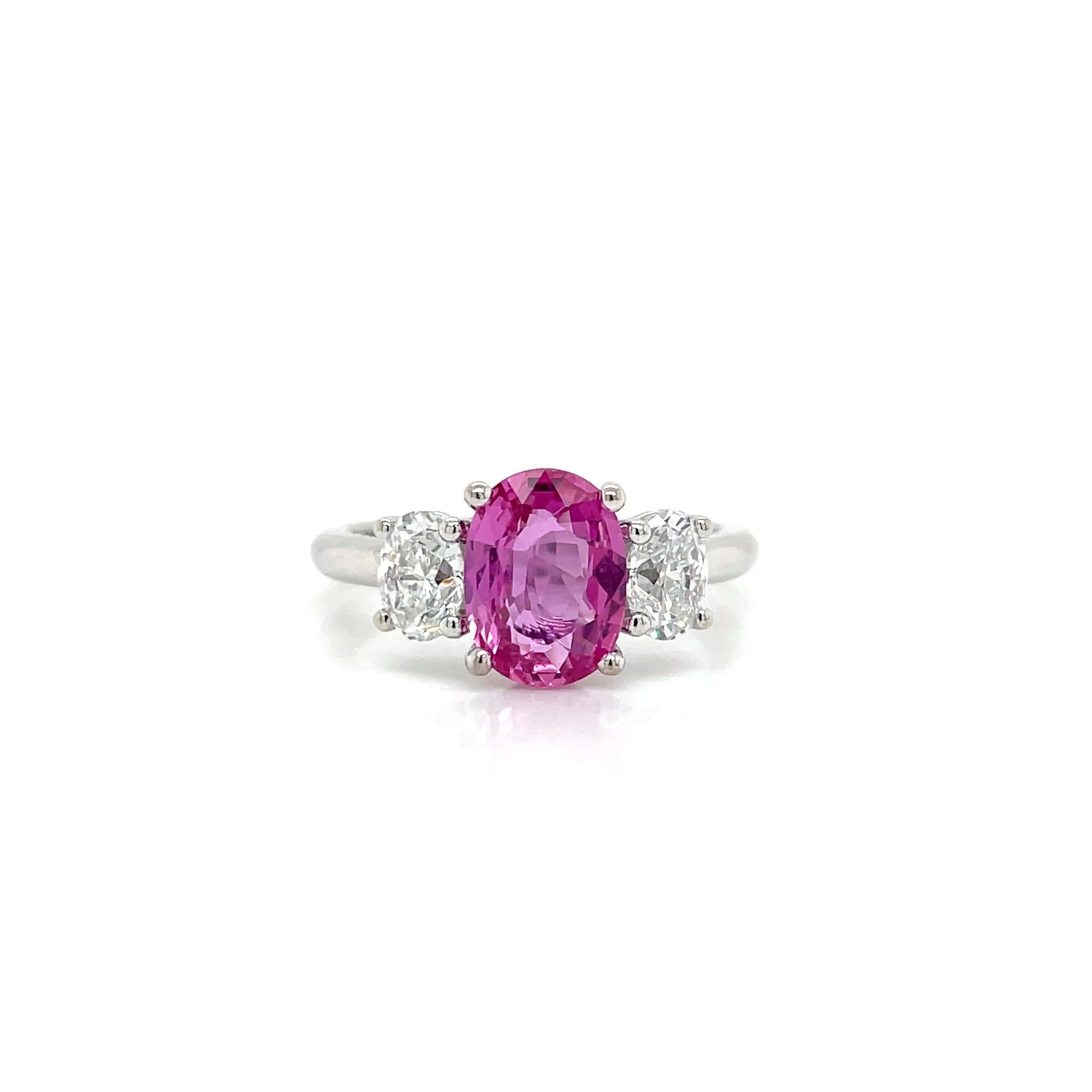 La bague contient au centre un saphir rose ovale brillant de 1,74ct et deux diamants ovales brillants assortis de 0,85tcw. Les diamants sont de couleur G et de pureté VS2, d'une excellente taille. Toutes les pierres sont montées en 18k blanc.