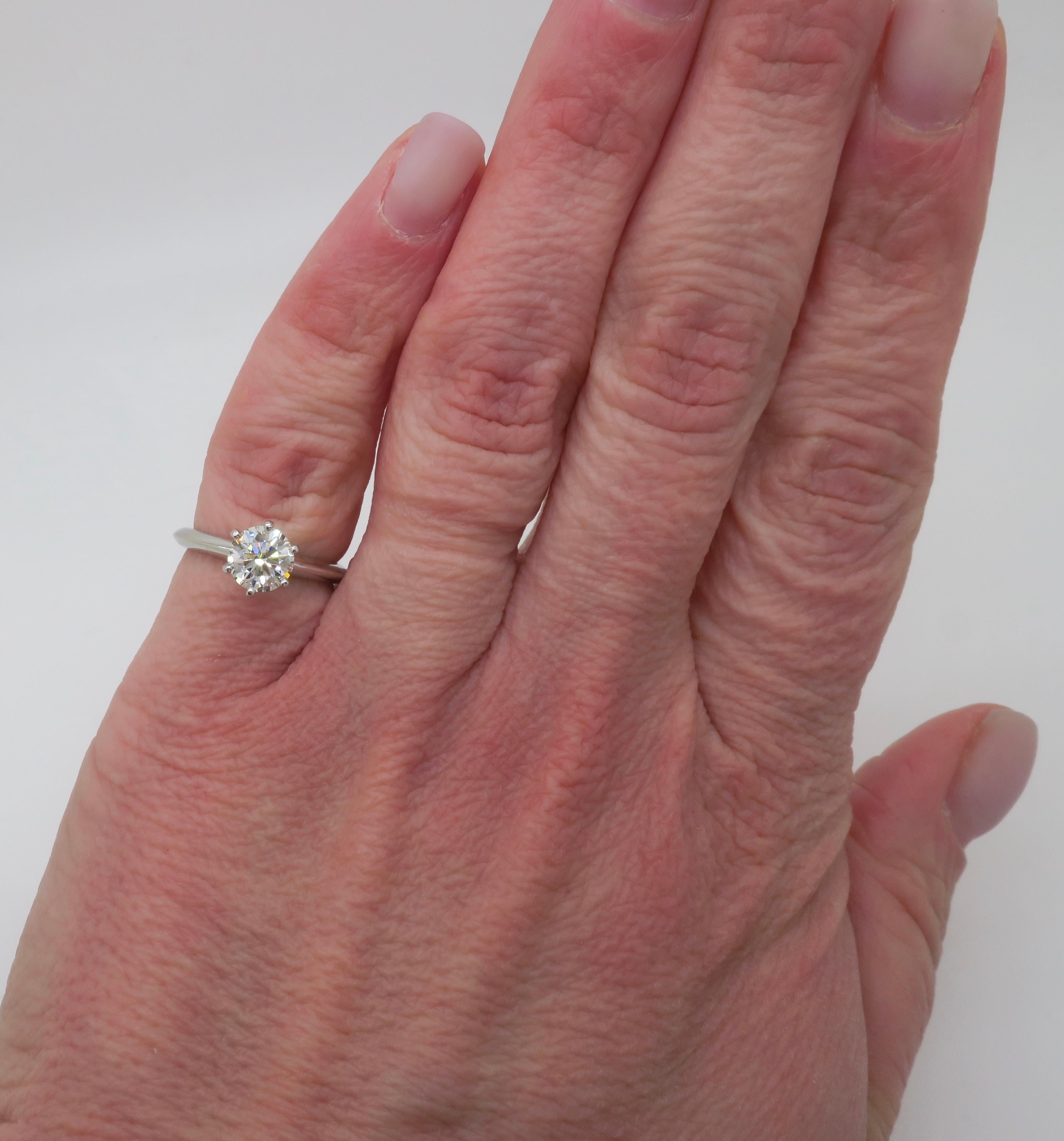 Authentic Tiffany & Co. classic diamond solitaire ring made in Platinum. 

Diamond Carat Weight: .90CT Earth Mined
Diamond Cut: Round Brilliant
Diamond Color: I
Diamond Clarity: VVS2
Metal: Platinum
Stamped: 