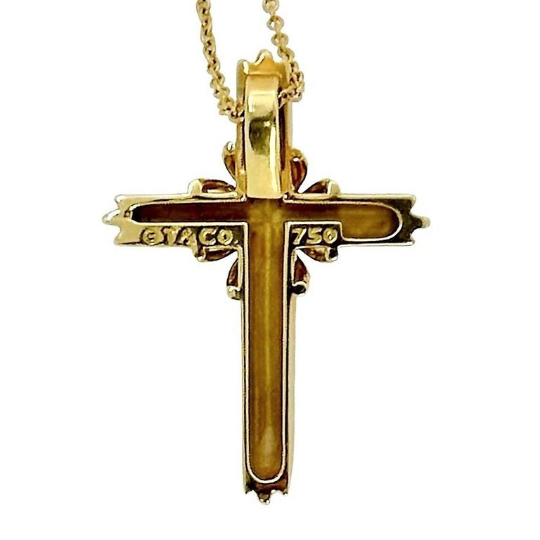 This classic Tiffany & Company 18K yellow gold religious cross is set at it's center with one brilliant cut diamond weighing approximately .10ct. Diamond quality is F color and VS1 clarity. The cross measures 1 1/16 inches long by 3/4 inch wide. It