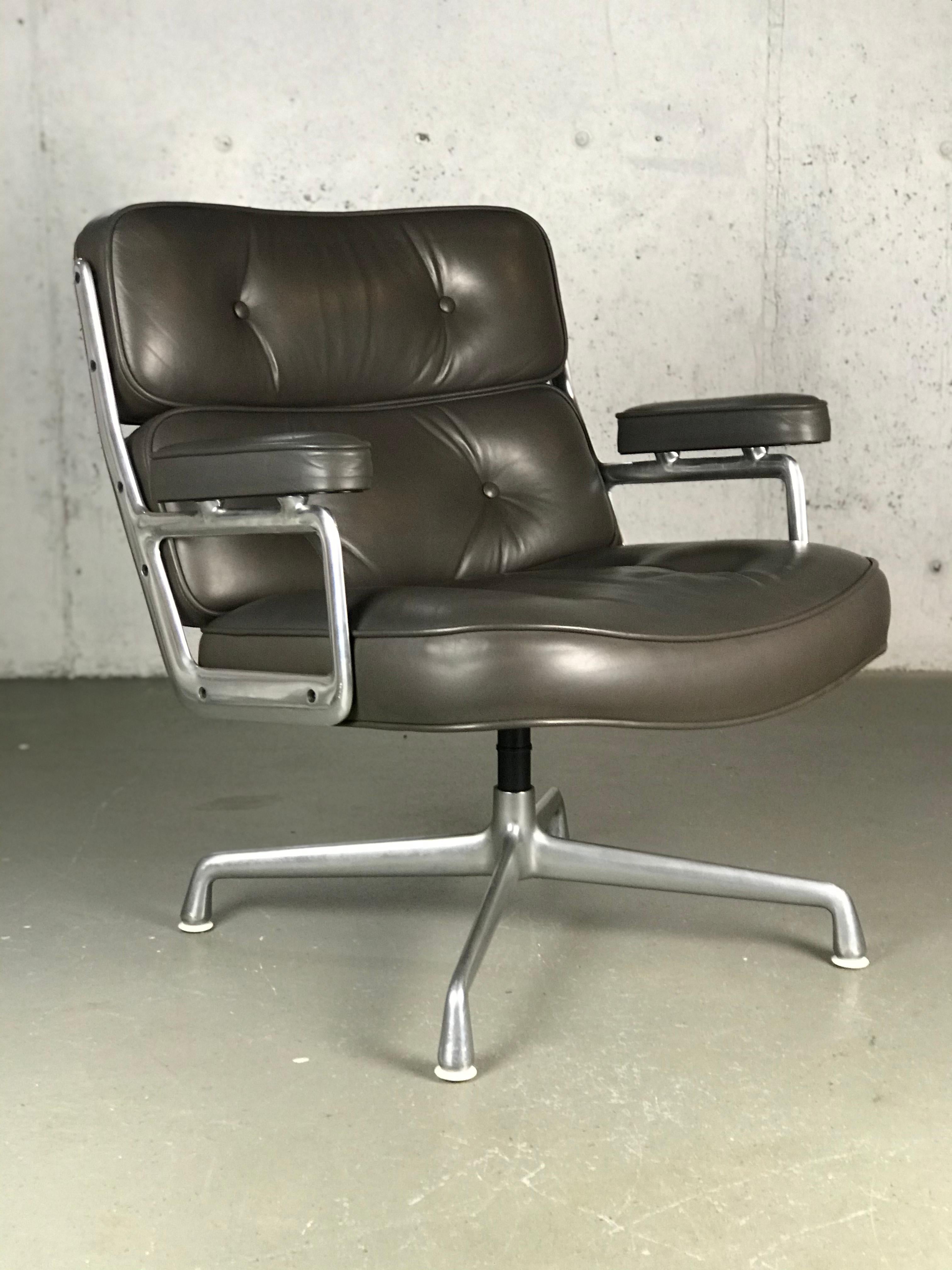 Executive lounge chair by Charles and Ray Eames. Original condition. Original grey leather with a light brown hue. The aluminum frame has wear/abrasions - leather has some wear as well. Indintation in the top. Faint crease along the top of the back
