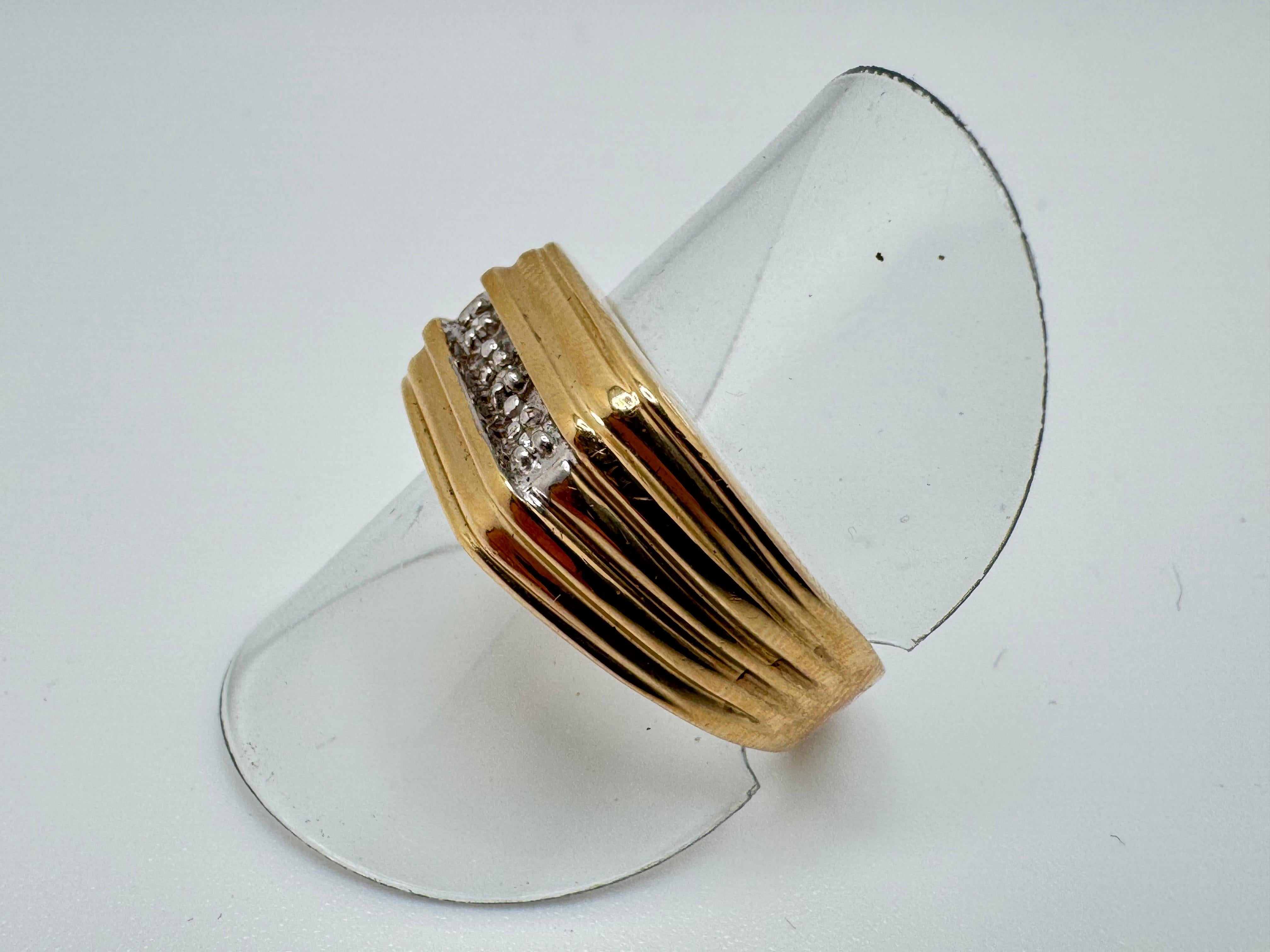 Questo anello da uomo è realizzato in oro giallo 10K e presenta un design classico e pulito dal fascino senza tempo. Al centro ci sono tre diamanti rotondi incastonati in fila, ognuno dei quali è tenuto saldamente in posizione di rebbi per esaltarne