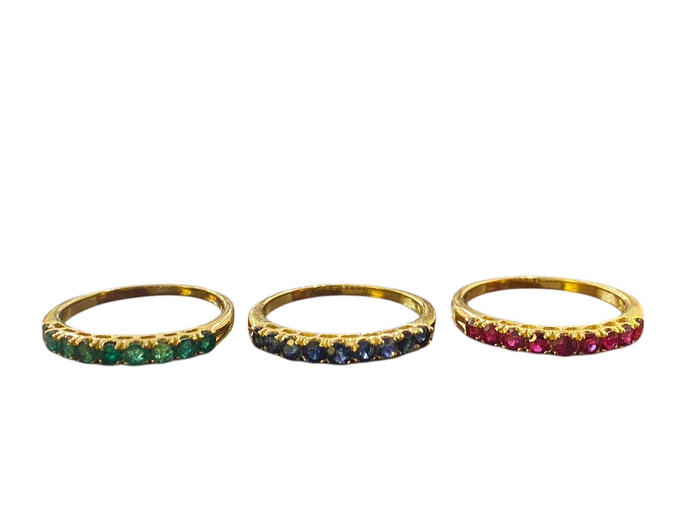 
18kt – 750‰ yellow gold band ring, composed of three movable rings: one with 9 emeralds, another with 9 rubies and the third one with 9 sapphires. The rings can be worn together or separately, providing versatility and elegance.