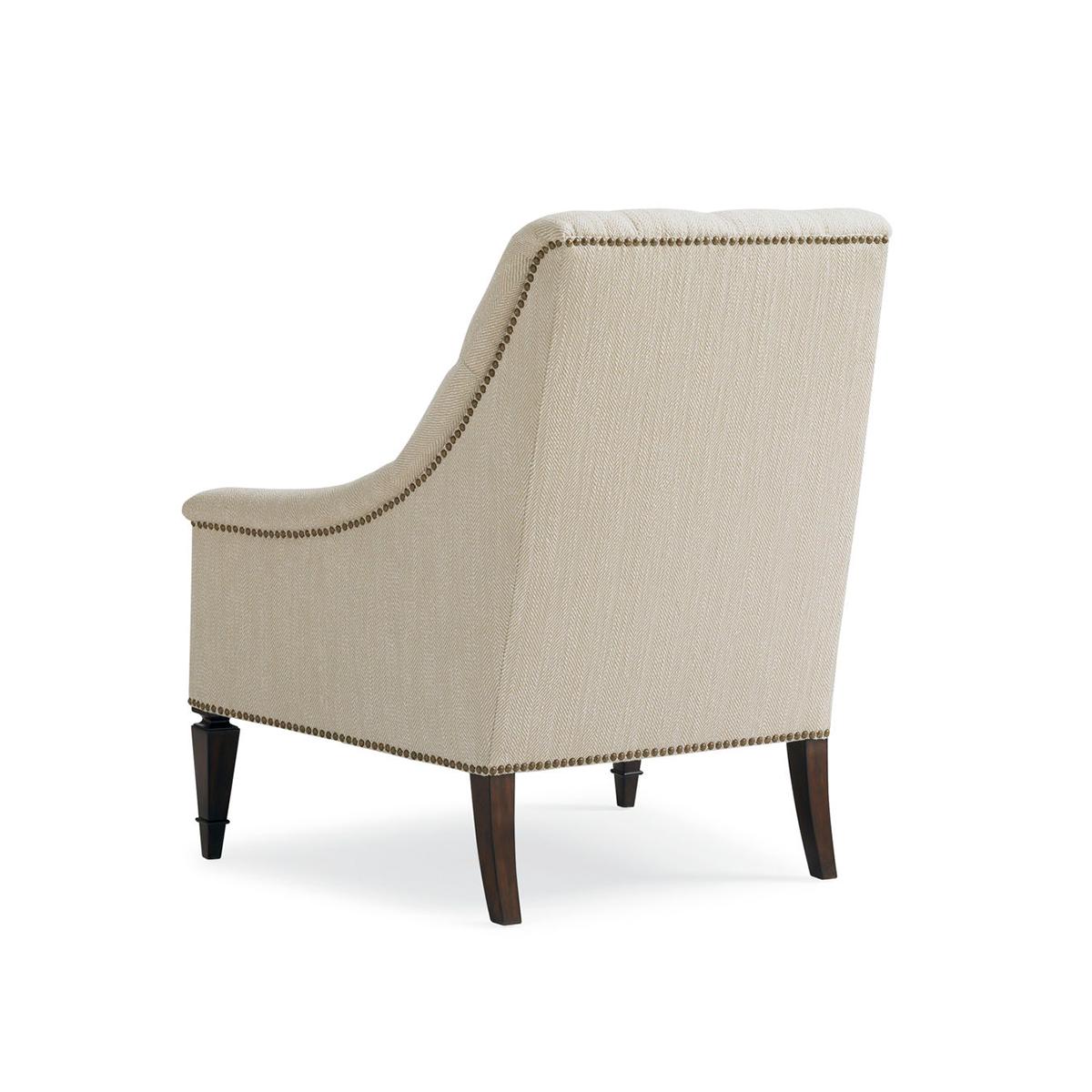 With a tufted and upholstered backrest and cushion, with brass nailhead trim details raised on traditional square tapered legs.

Dimensions: 33