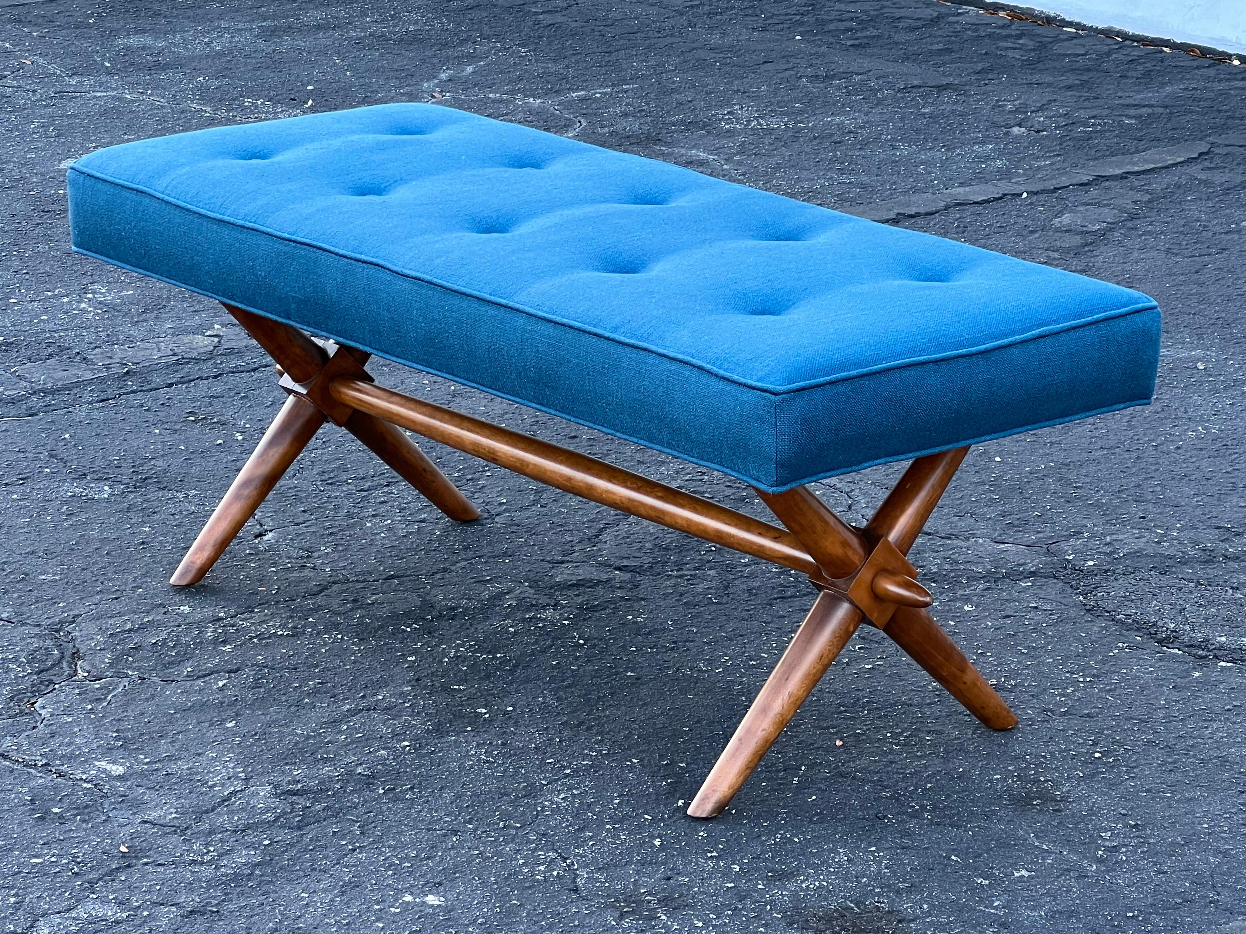 A classic upholstered bench by T.H. Robsjohn-Gibbings for Widdicomb. Feauturing an X form base. Walnut frame, upholstered in 100% Belgian linen by Brunschwig & Fils, 