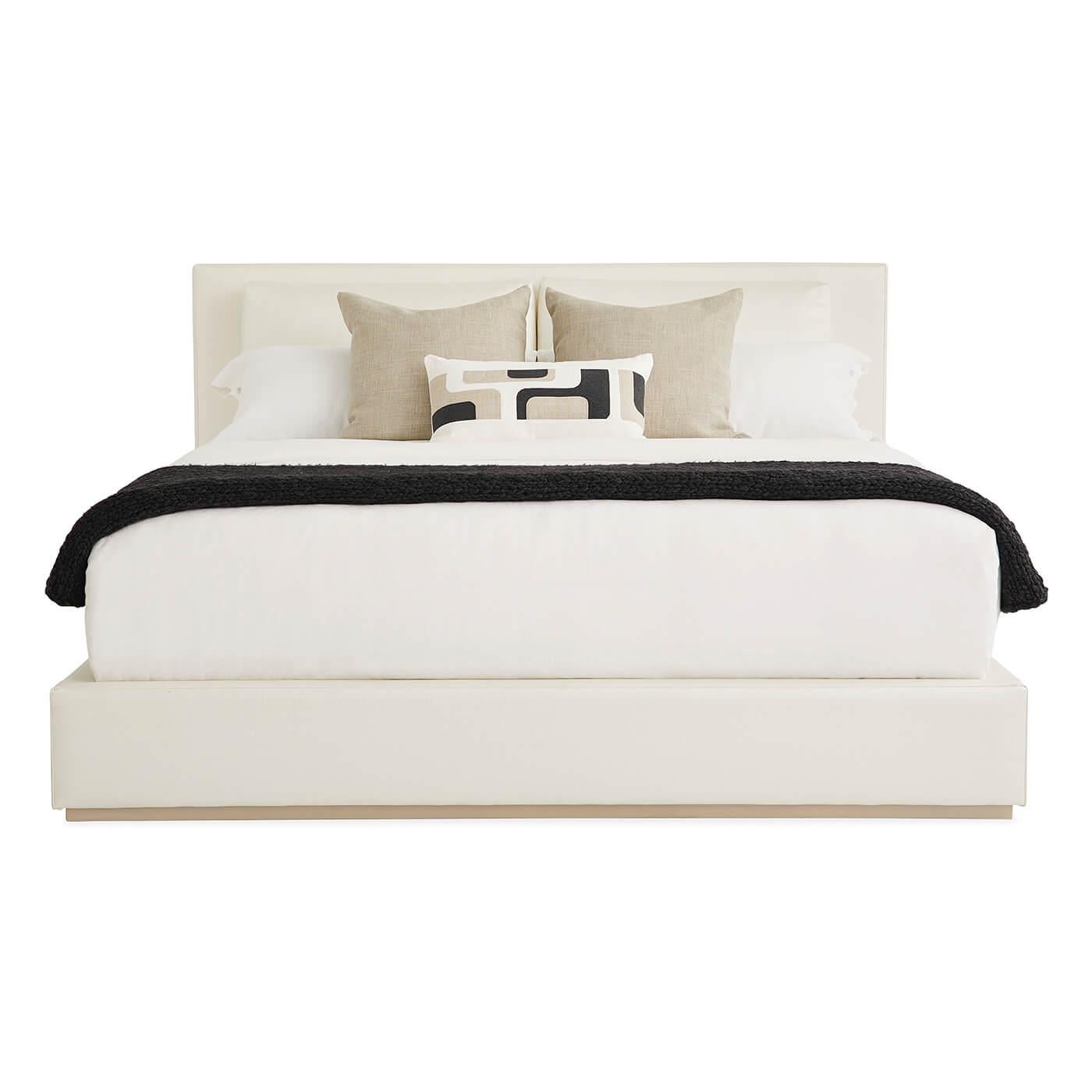 A modern classic upholstered platform king bed. The elegant bed combines the comfort of your favorite refined boutique hotel with the authentic charm of a modern Paris apartment. Dressed in crisp white grasscloth textured vinyl, its chic design is a