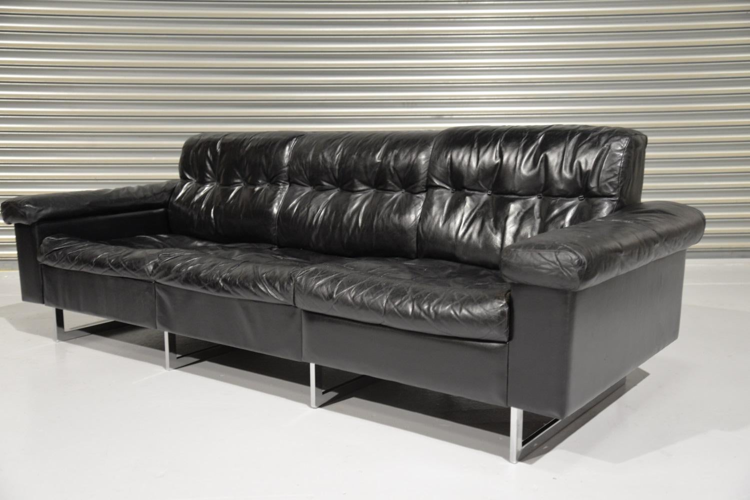 A vintage de Sede three-seat sofa in stunning black leather. Hand built in he 1970s by de Sede craftsman in Switzerland, this original sofa stands on polished chrome-plated legs. This stylish sofa is over 40 years old, as expected clearly shows