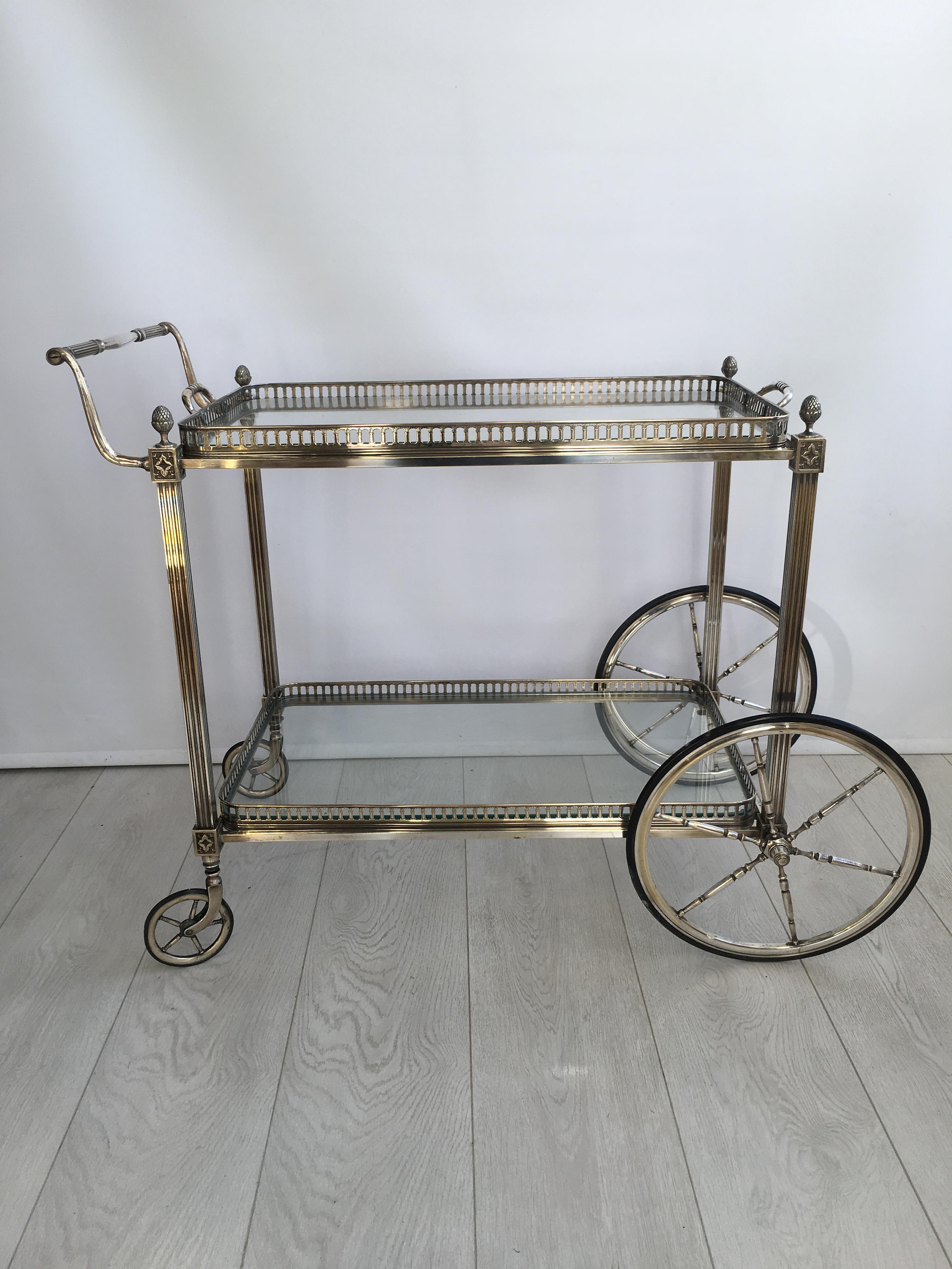 Classic vintage drinks trolley from France, circa 1950 with lift off tray.

Polished silver finish with lovely coloring, going back to the brass in places (please see close up images).

Decorative finials with reeded legs and bottle holder to