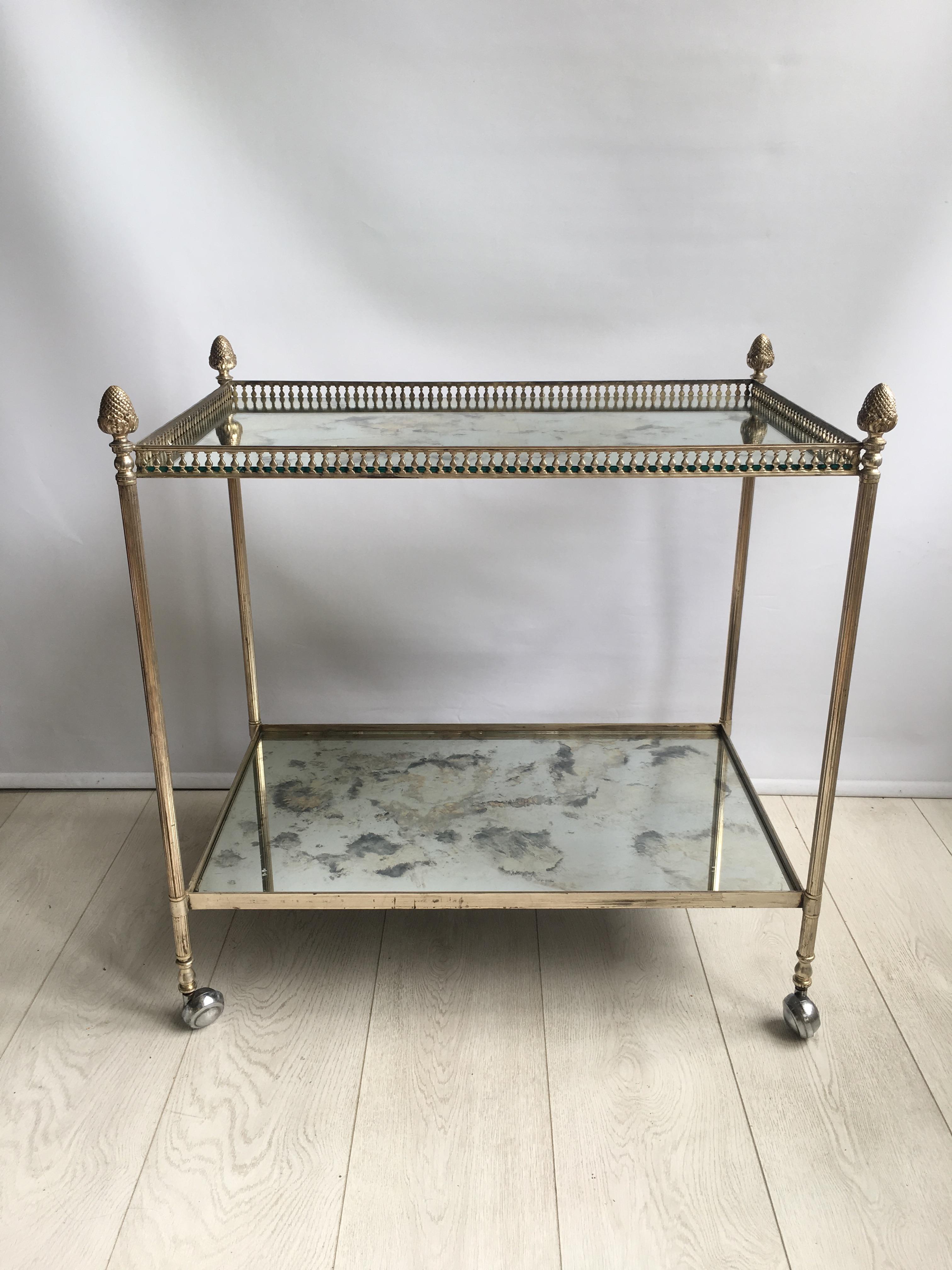 Classic vintage drinks trolley from France, circa 1960

Nickel/silver in color with decorative finials. 

Mirrored glass shelves with a few nibbles to the corners (please see close up images)

One of the larger drinks