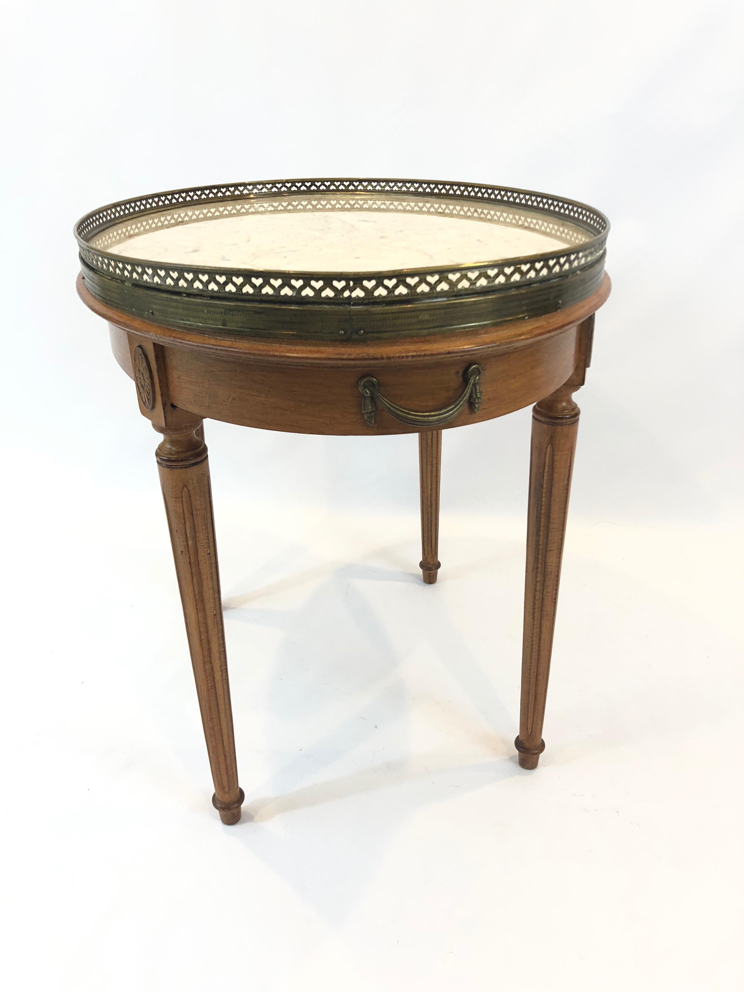 A lovely classic oval cocktail table in a small to medium size having French style carved wood base and creamy marble top with pretty brass gallery. 22.25 H to top of brass gallery.