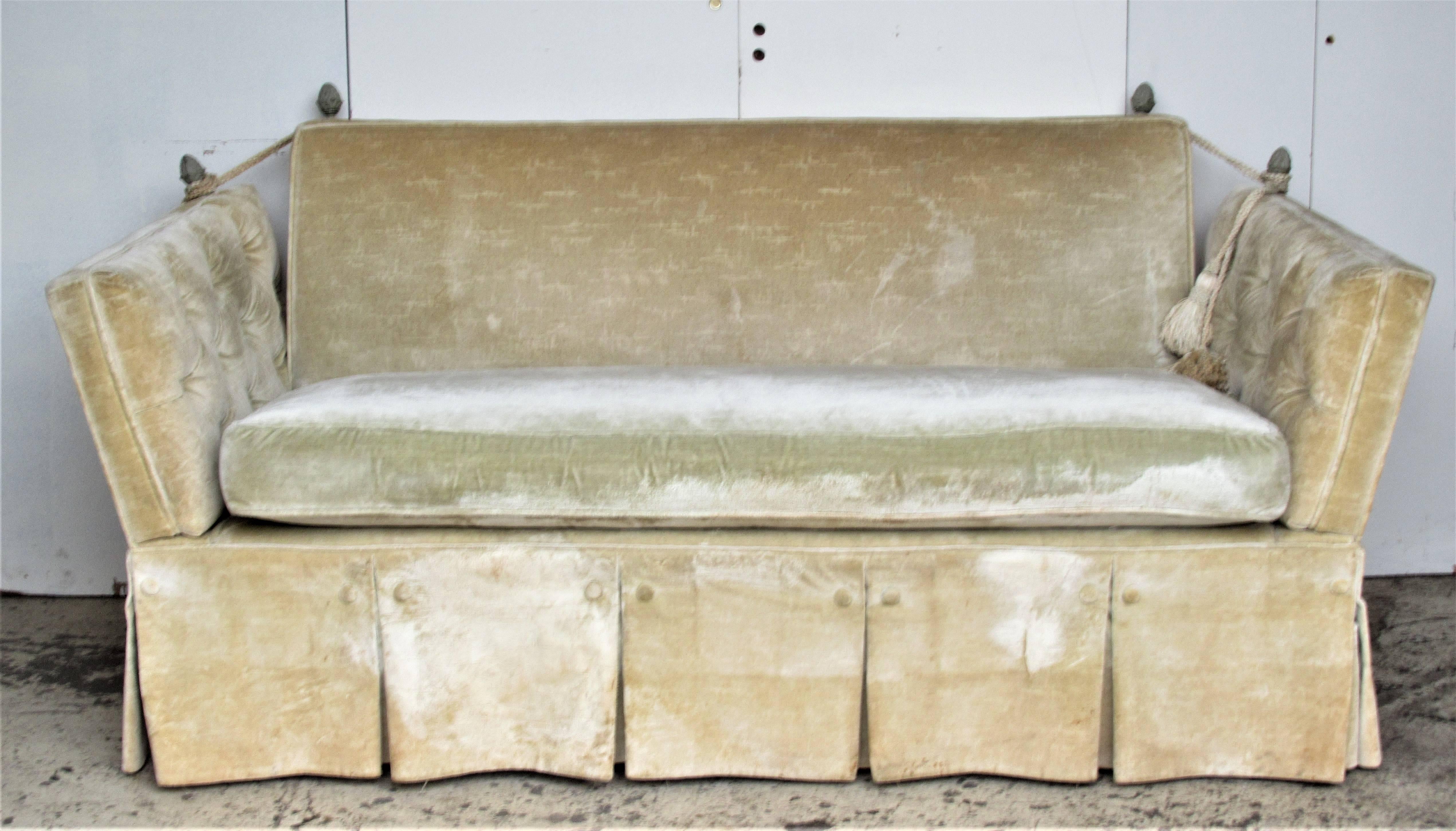 Classic antique English style Knole button tufted sofa in original pale vellum colored cotton velvet upholstery / the tailored skirt is fully buttoned at all four sides concealing four square nicely tapered wood legs / old pale gray painted brass