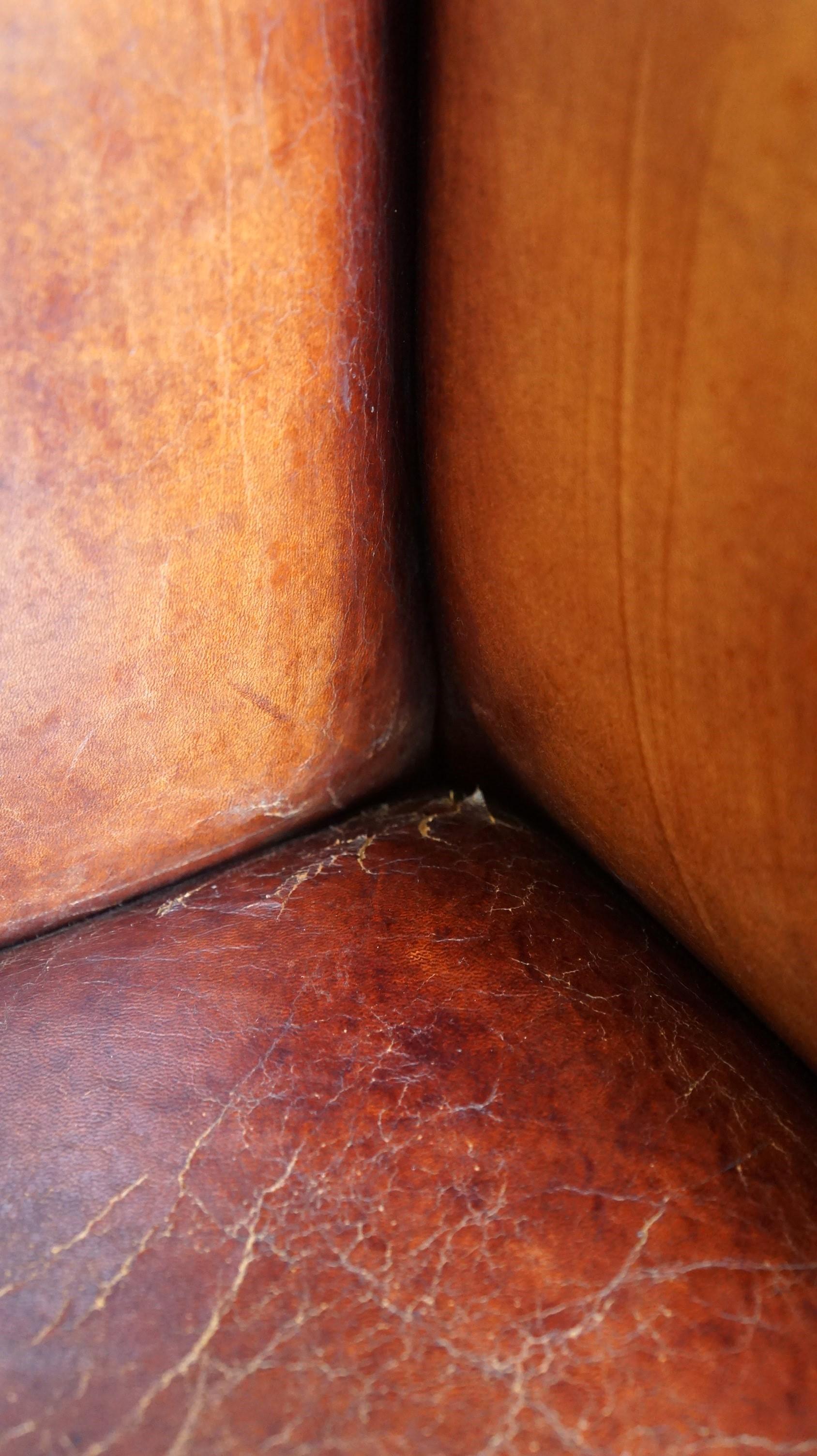 Clásico sillón de orejas de piel de oveja vintage con un bonito acabado y colores cálidos en venta 9