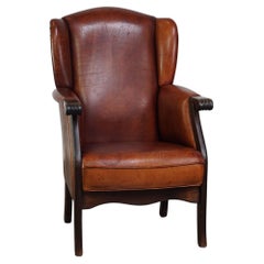 Fauteuil à oreilles classique en peau de mouton vintage avec une belle finition et des couleurs chaudes.