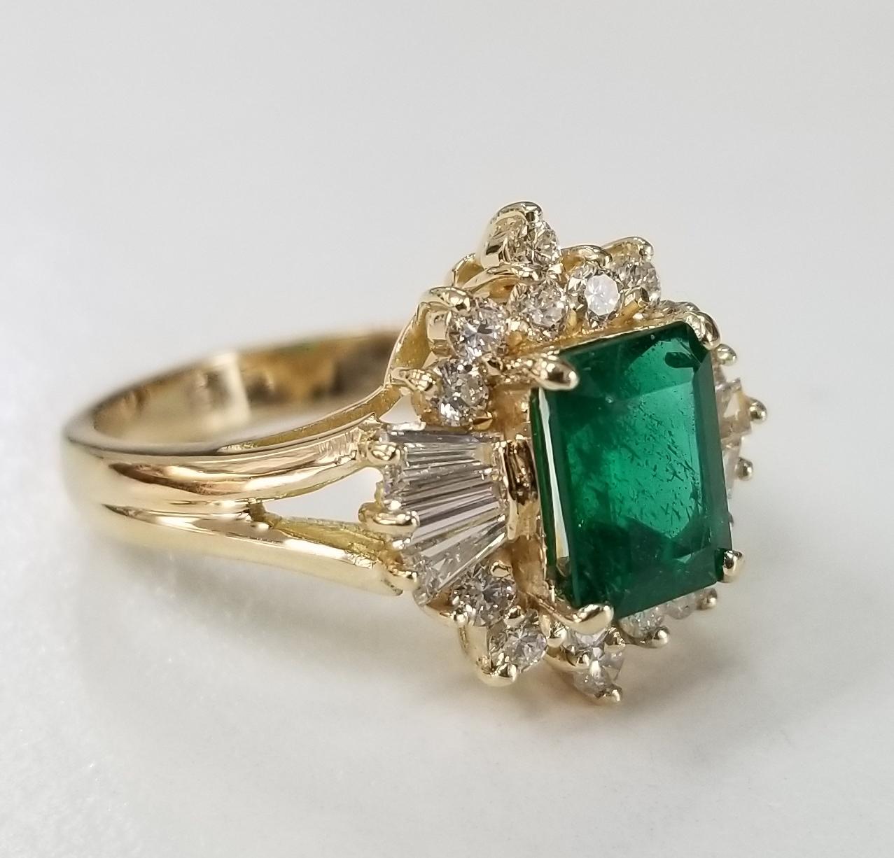 14 karat yellow gold emerald diamond ring, containing 1 GIA emerald cut emerald of gem quality weighing 1.59cts.,surrounded with 14 round full cut and 6 baguette cut diamonds diamonds of fine quality weighing .86pts.  This ring is a size 7 but we