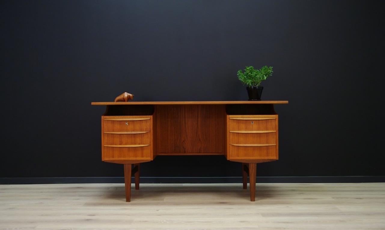 Retro desk from the 1960s - Danish design, Minimalist form finished with teak veneer. Handles and legs made of teak wood. It has six capacious drawers at the front, bookshelves and an open bar at the back. The key in the set. Preserved in good