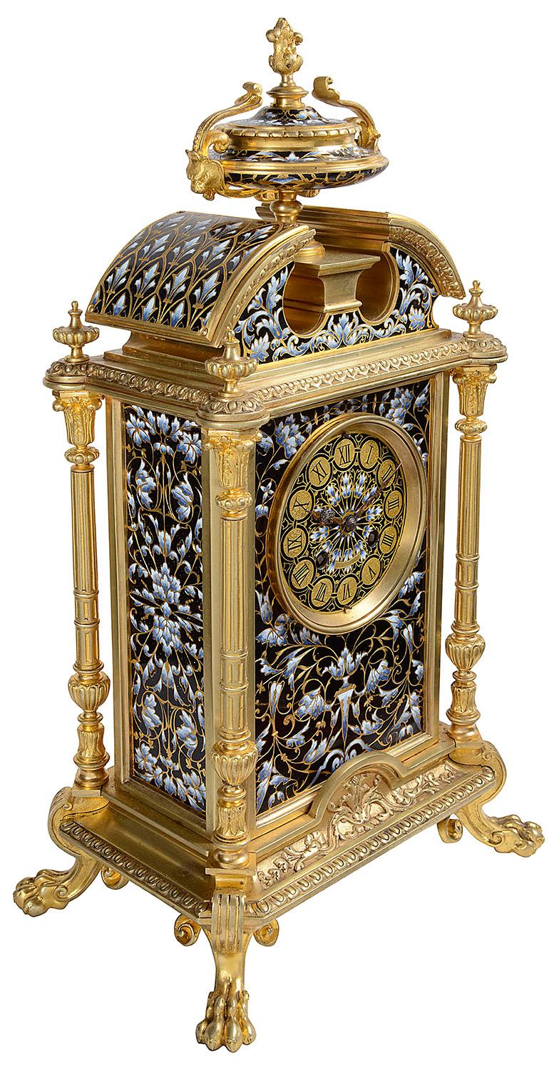A very good quality late 19th century French Louis XVI style gilded ormolu mantel clock. Having a broken arch pediment with a twin handled urn to the centre. The inset champlevé enamel panels with floral and foliate decoration. Classical gilded