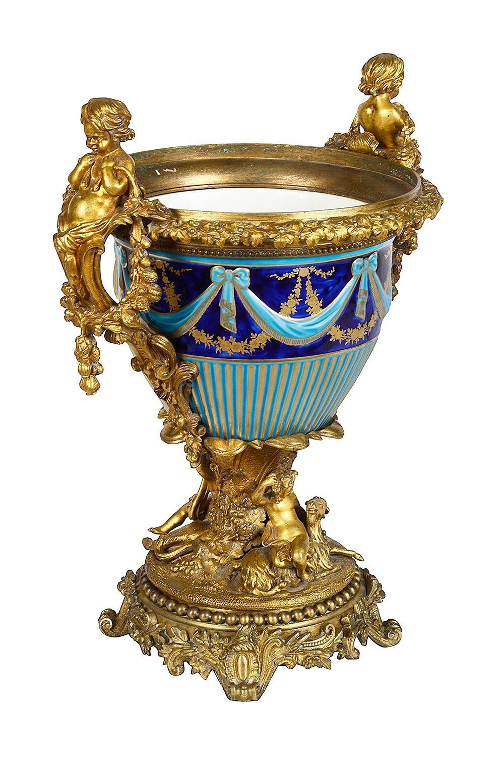 A very good quality 19th century French cobalt and turquoise blue majolica porcelain urn, with wonderful gilded ormolu mouldings and mounts of putti holding garlands of flowers, among grape vines.
Batch 76 60676 DTNSK