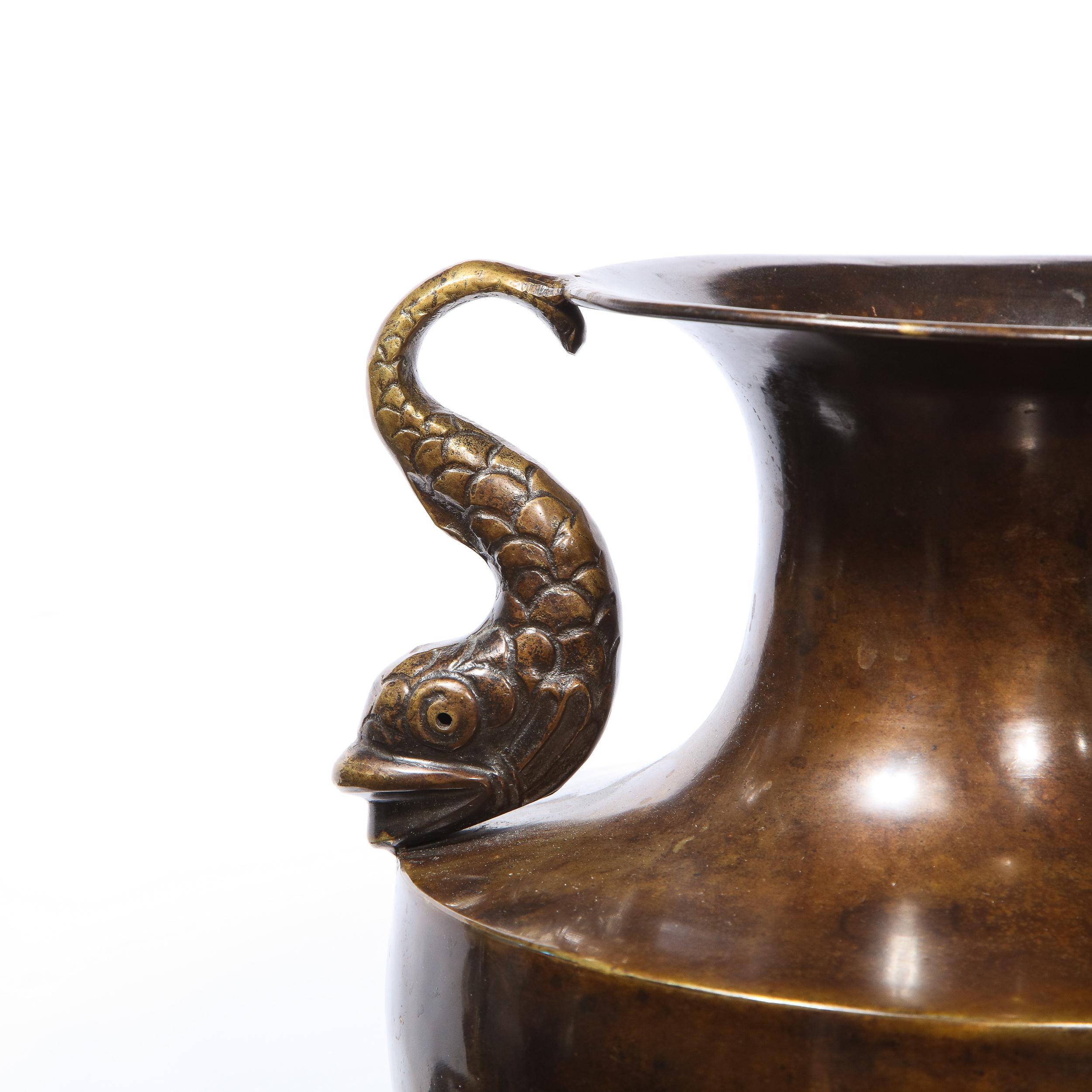 Questo elegante e grafico vaso classico del XIX secolo è stato realizzato in Svezia. Presenta una base quadrata che sale in un filetto ondulato e un corpo a forma di urna con collo cilindrico e bocca svasata, il tutto in un bellissimo bronzo. Il