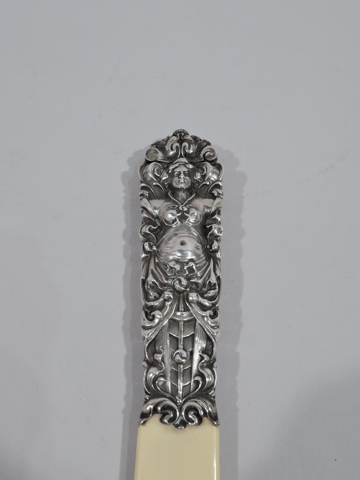 Turn-of-the-century classical Art Nouveau letter opener. Tooled and tactile double-sided silver handle in form of bosomy caryatid with drapery stretched over round belly. Blade flat with u-form tip. Appears to be unmarked. Gross weight: 1.6 troy