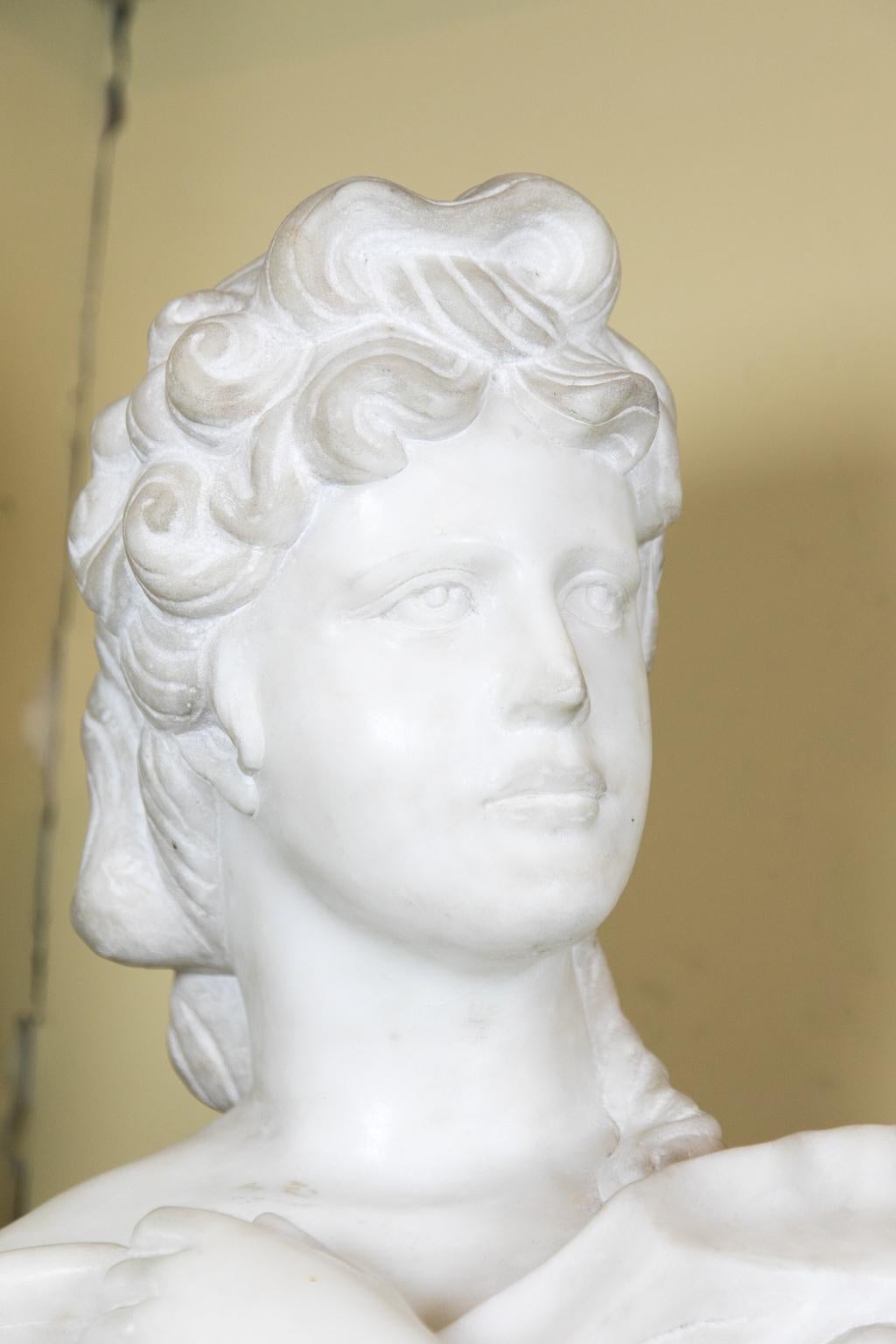 Classical carved marble bust has a draped vest.